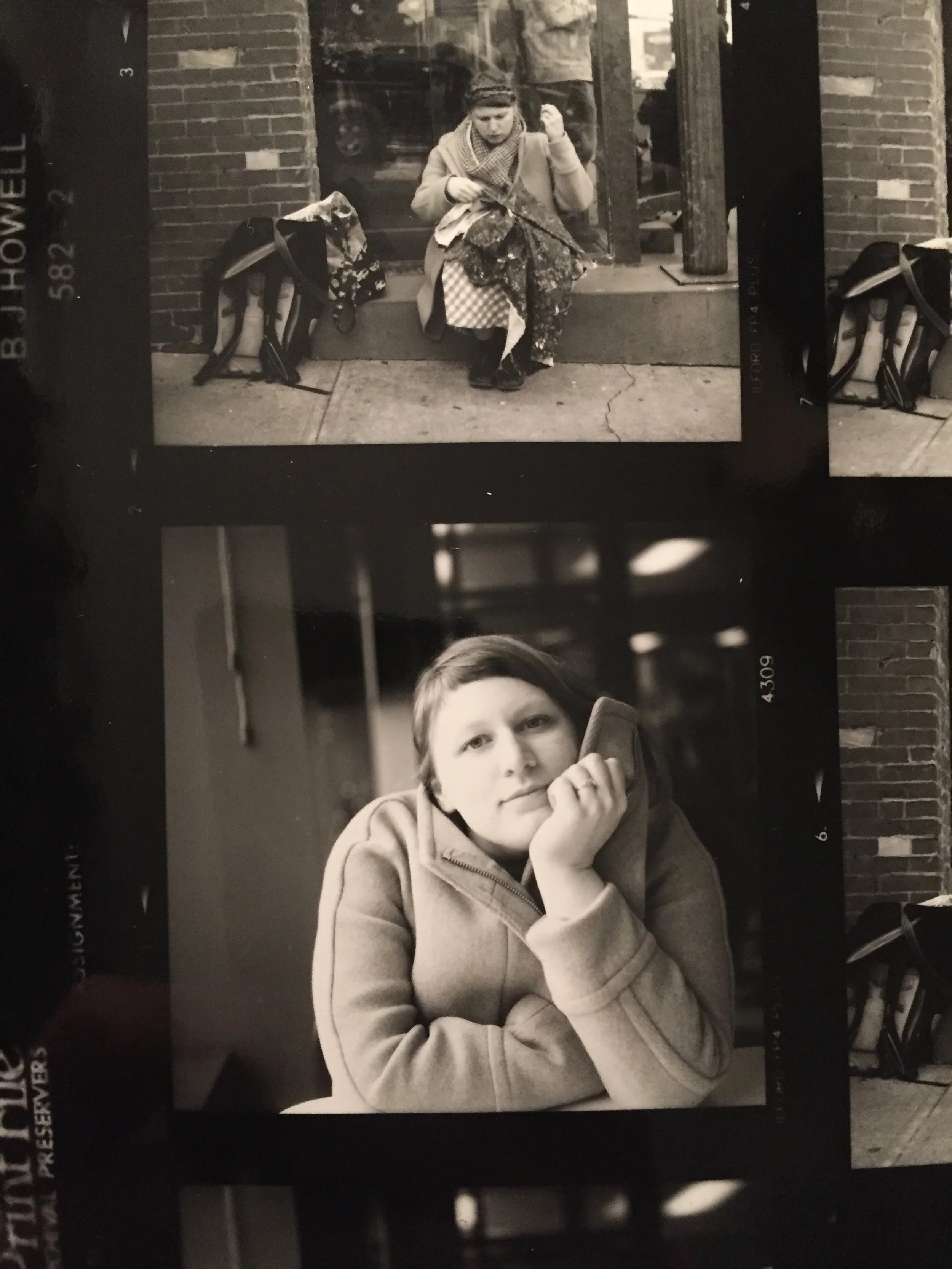Black and white photo of a woman sitting on a curb outside a brick building, looking down at something in her hands, with a backpack beside her. Below, a photo of a young girl with short hair, resting her chin on her hand, looking directly at the camera.