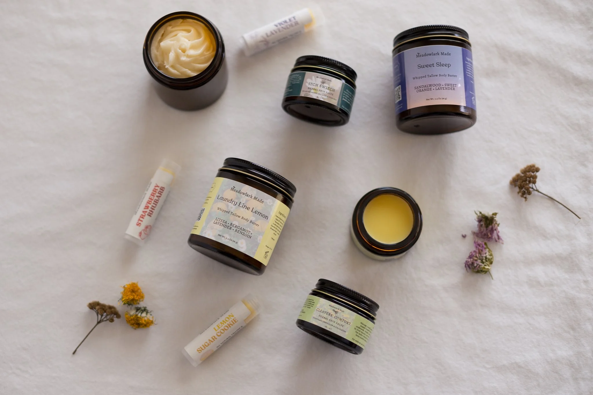 Spring Collection by Meadowlark Made with bright citrus aromas and spring herbs, displayed on a white cloth with dried flowers.