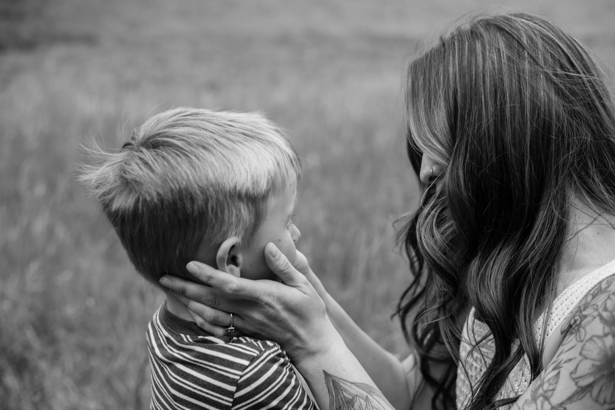 Sydney, co-owner of Meadowlark Made, gently holds the face of her son with light hair, looking at him lovingly.