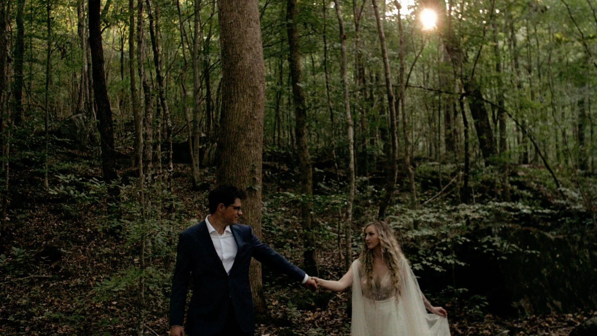 Bride and Groom walking through woods on wedding day in Pot Point Park, Tn.