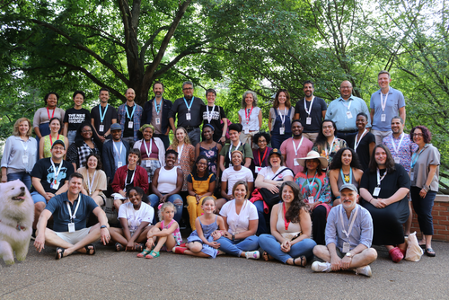 Company photo of New Harmony Project taken outside under trees with different writers and staff.