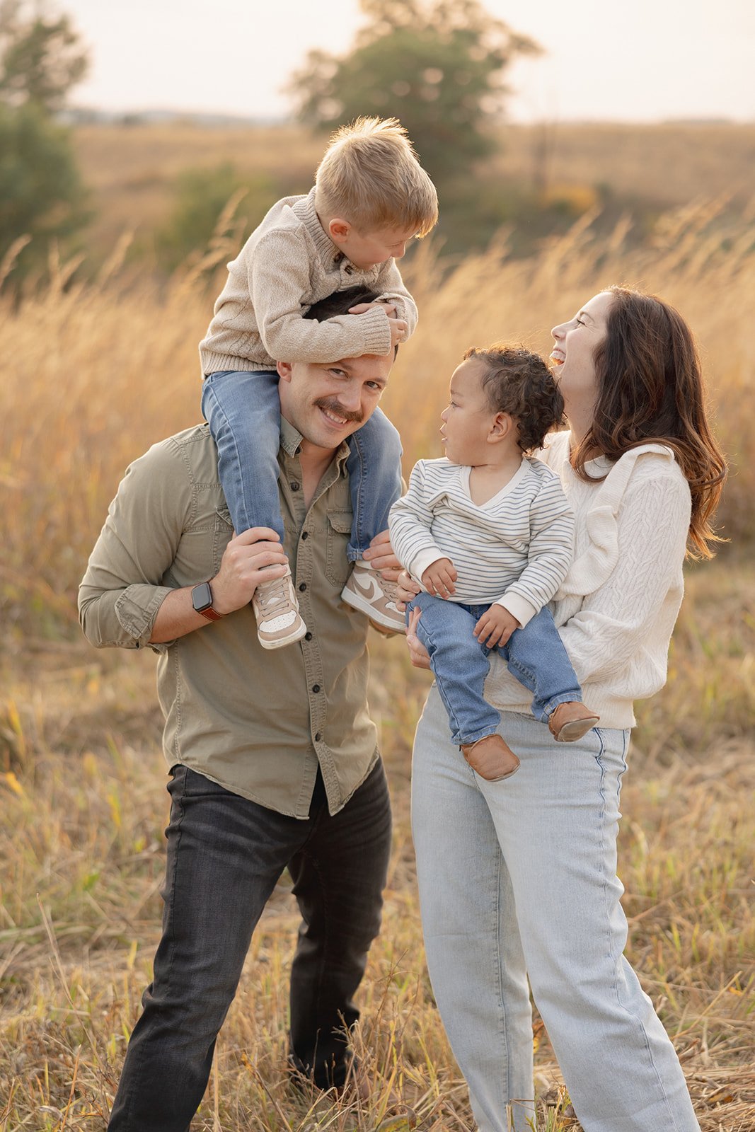 family of four getting their picture taken by the best iowa city photographer in the fall