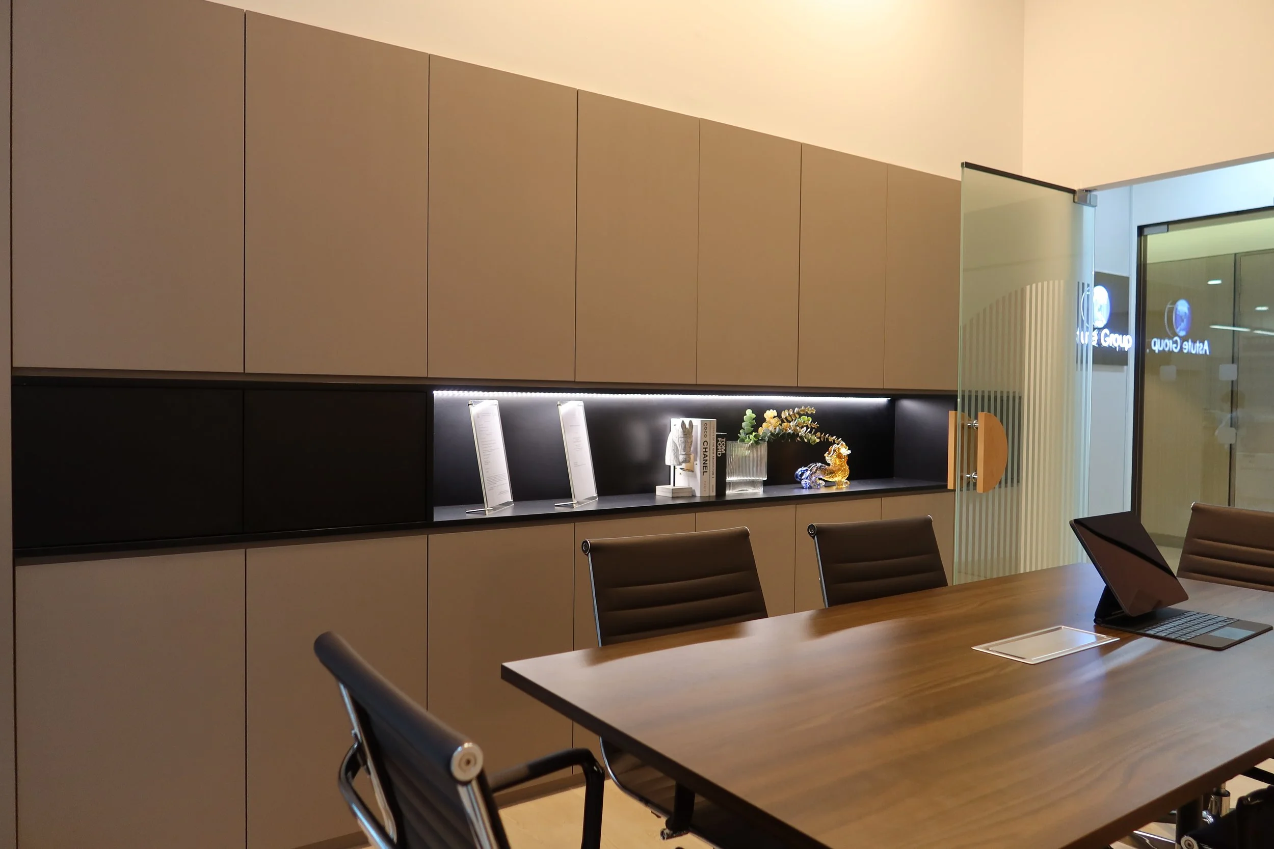 Modern office corridor with wooden wall panels, glass doors, and an exit sign at the end.