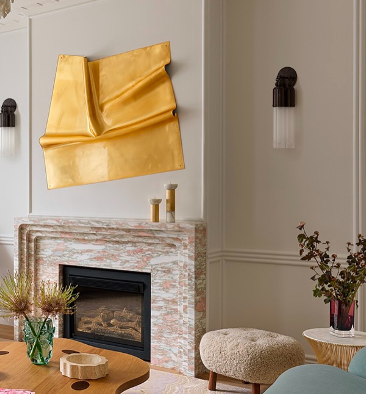 Timeless elegance, redefined.
This curved-edge marble fireplace is the heart of the room&mdash;crafted from natural stone that whispers luxury in every line. 

Above it, a stunning piece of gold wall art steals the show, anchoring the space with warm