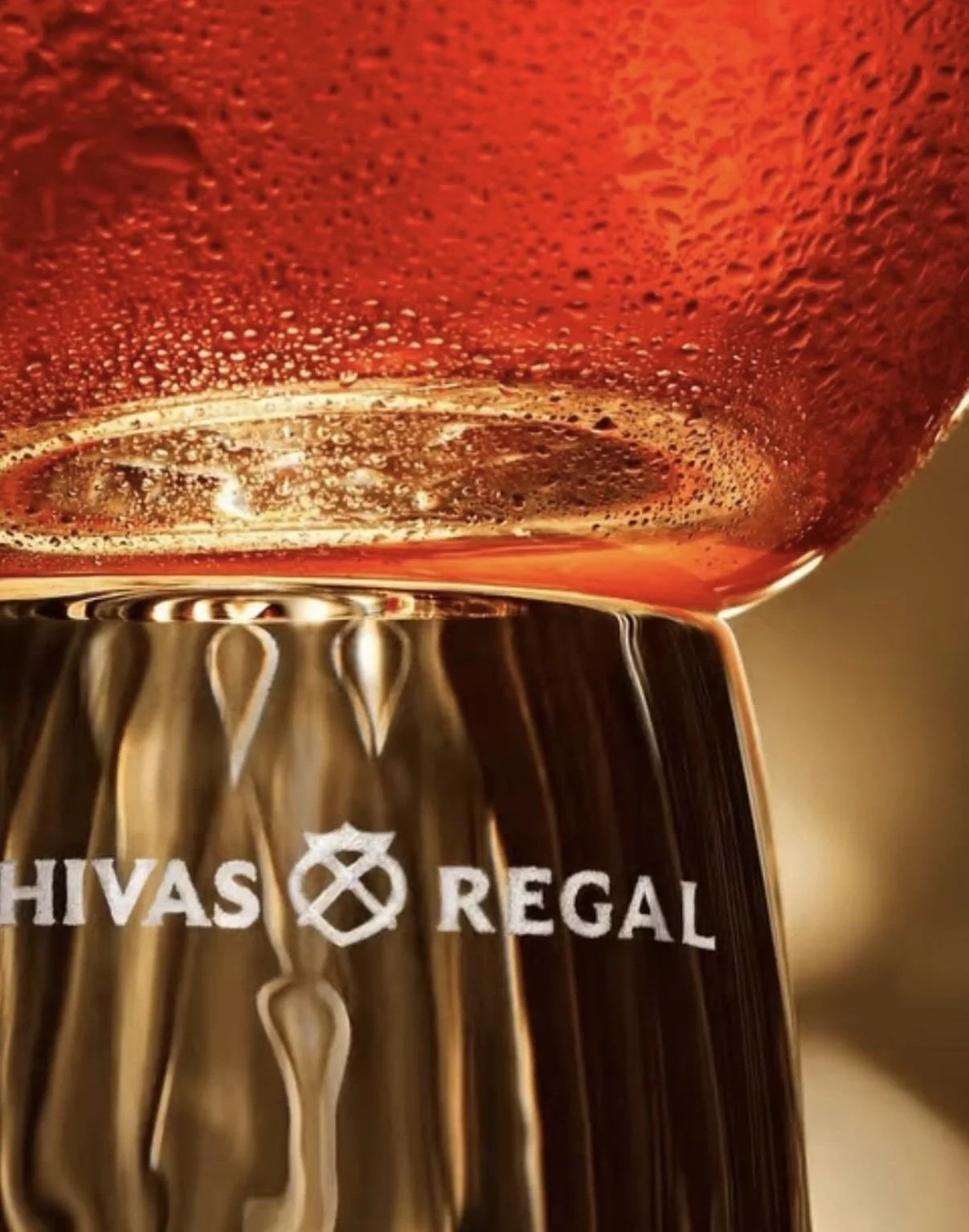 Close-up of a glass of rosé wine with condensation, displaying the logo of Havas Regal on the base of the glass.