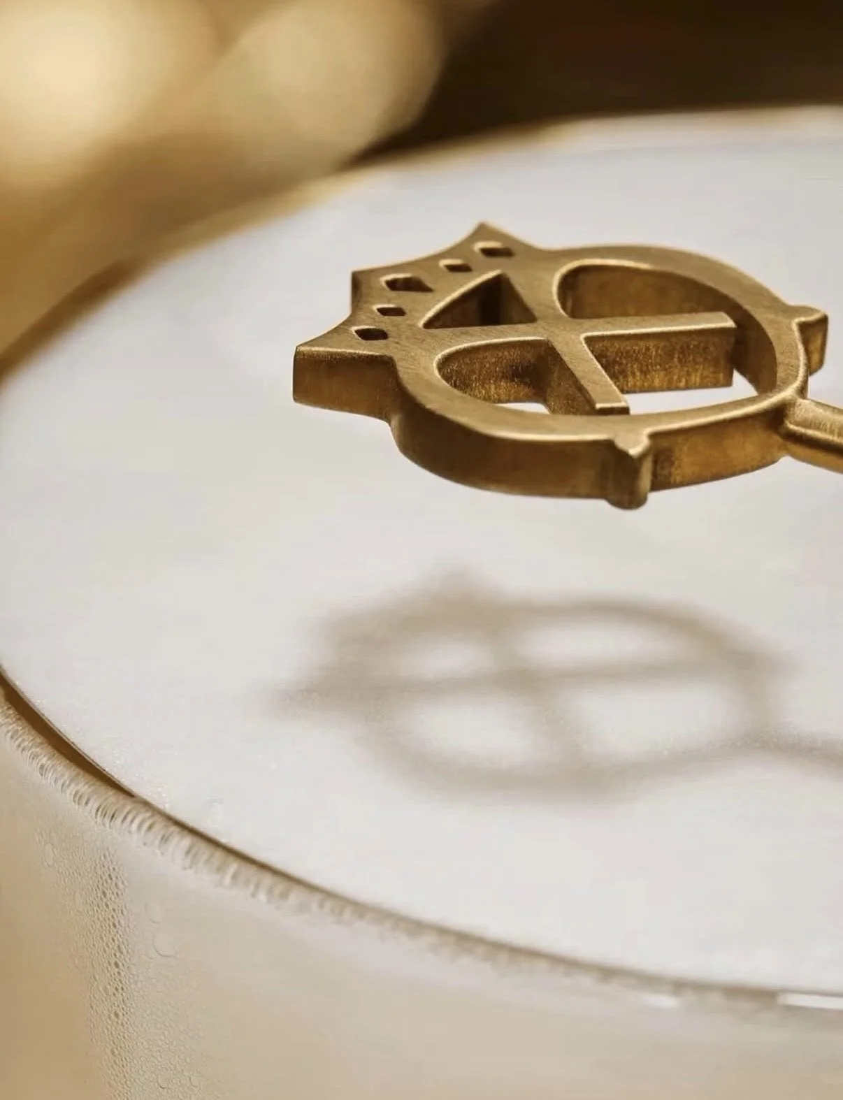 Close-up of a gold-colored penguin-shaped key floating above a white surface.