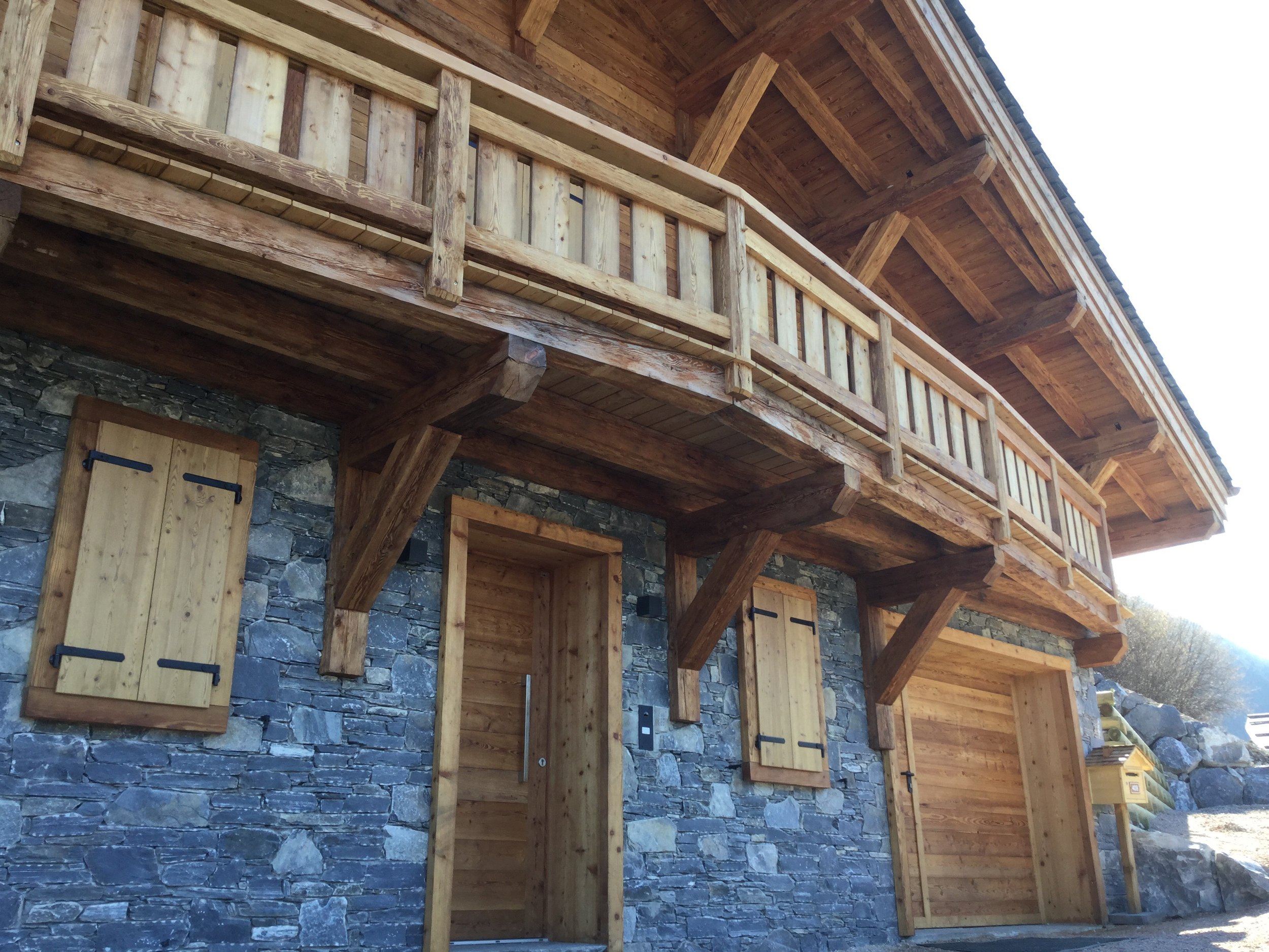 A chalet that combines modern architecture with glass and render with beautiful local stone and meleze wood