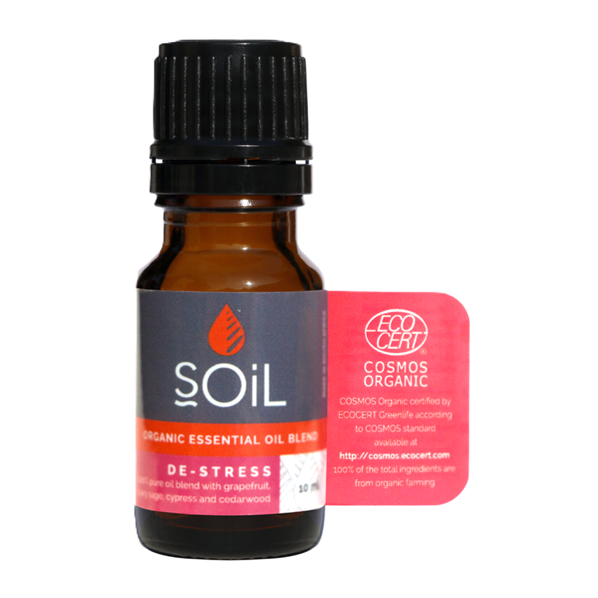 A small amber glass bottle of SOiL Organic Essential Oil Blend labelled 'De-Stress' with a black cap and a pink certification tag indicating ECOCERT Cosmos Organic certification.