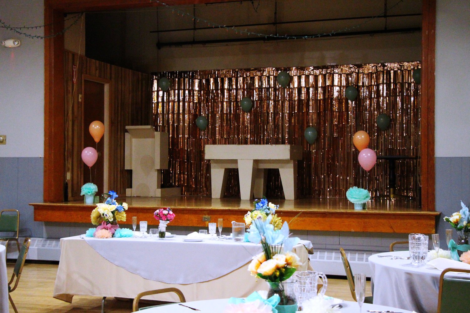 The wedding reception is not a joyous event and the festivities feel forced. The decor is cheap and the color palette is right out of the store. Those colors of pink, peach and mint green were standing out by having tablecloths matching the grey wall