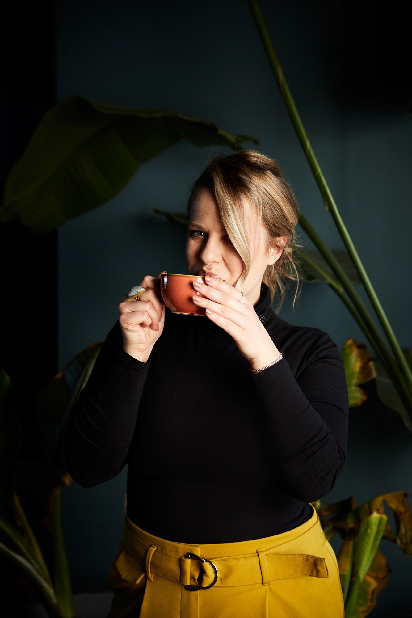 Cherish Amber couples coaching with a knowing smile from behind a terracotta cup.