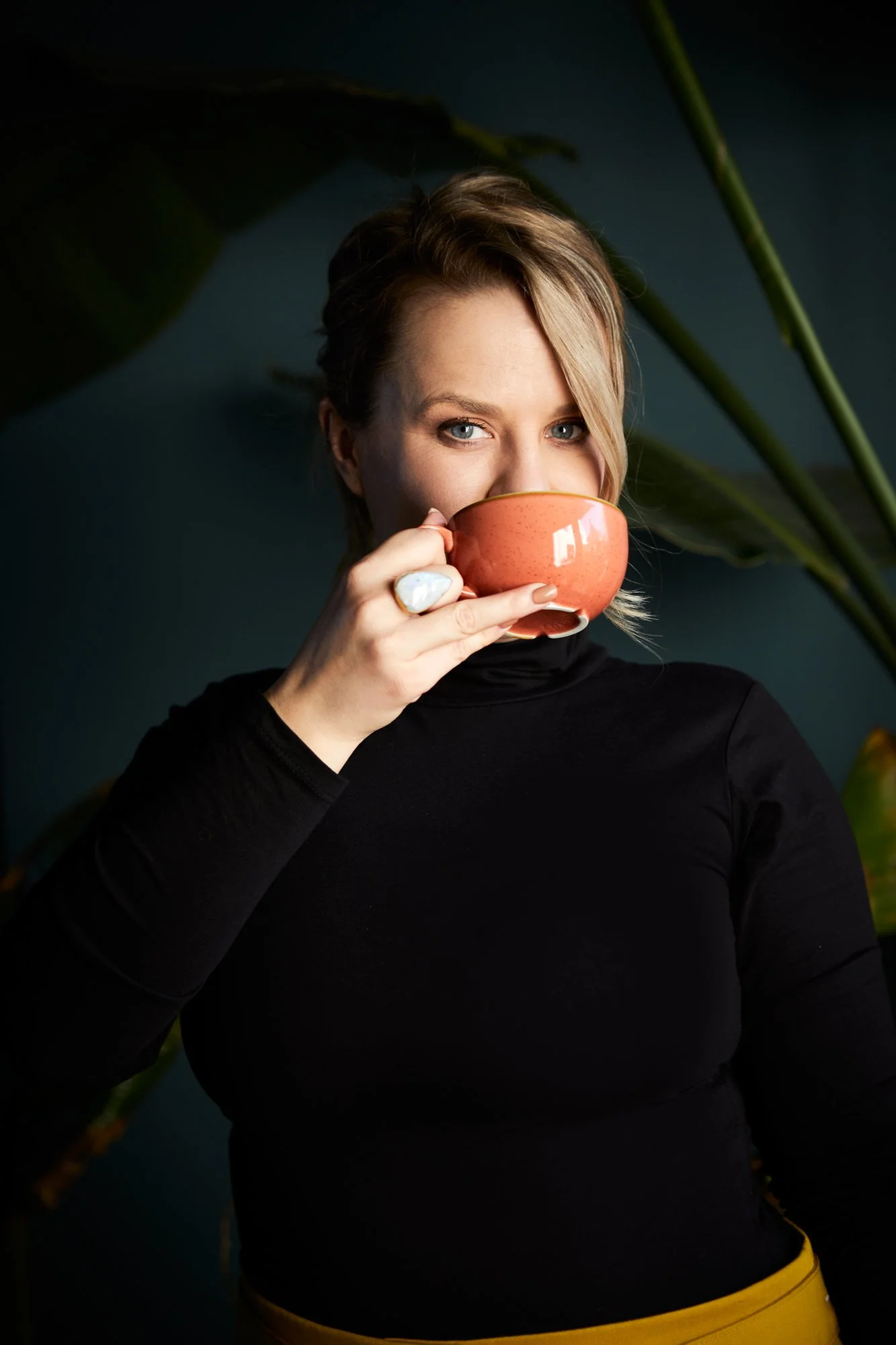 Cherish Amber holding a terracotta cup with a direct knowing gaze