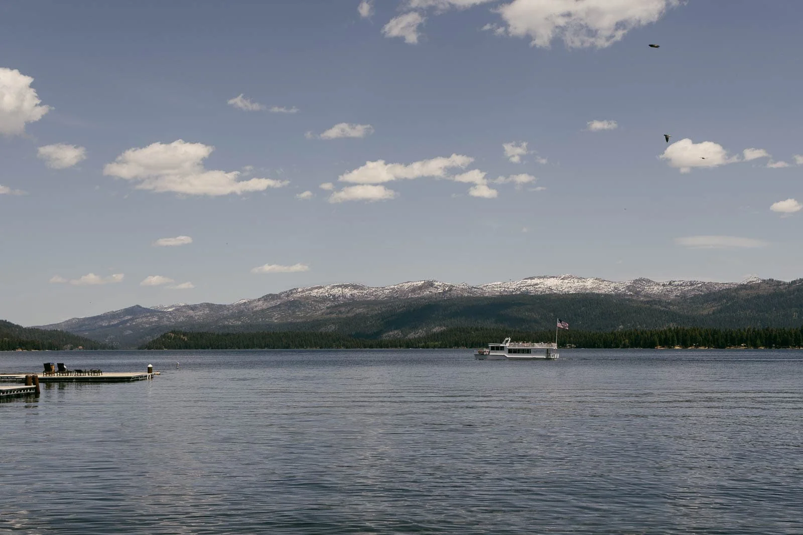 Payette Lake with cruise boat and snow-dusted mountains, McCall Idaho summer