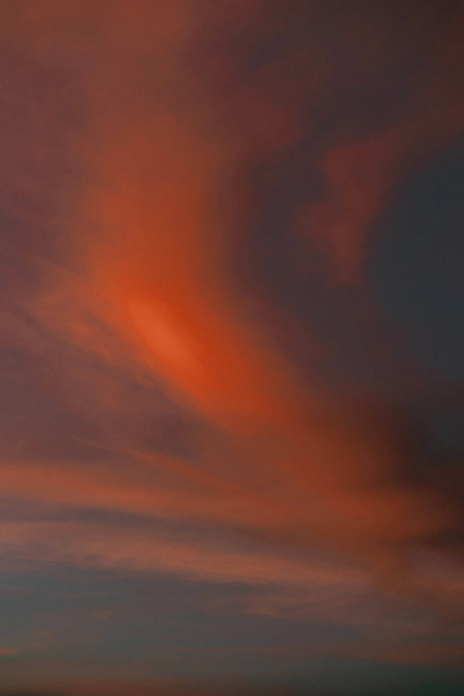  The desert sky at Bruneau Sand Dunes erupts in deep orange and red at sunset, wispy clouds catching the last light of the day in a warm, dramatic sweep across the horizo 