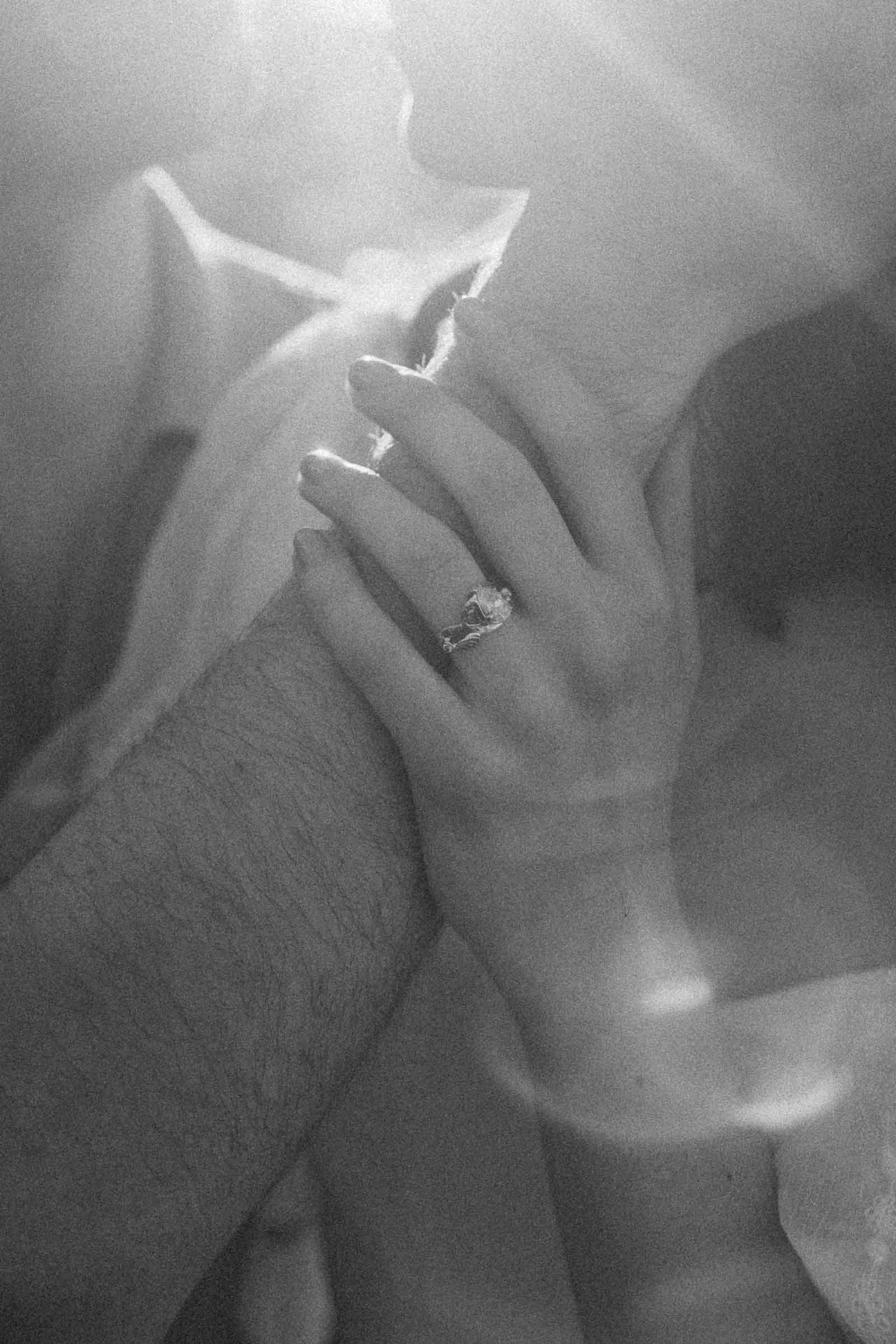  A woman’s hand wearing a ring rests gently on her fiancée’s arm. 