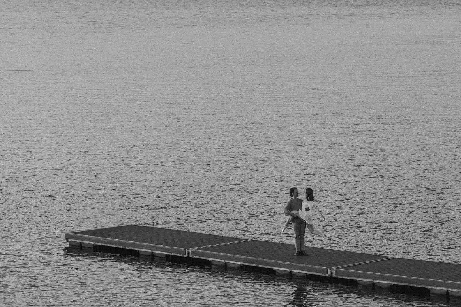  A couple dances on a floating dock on a lake. 