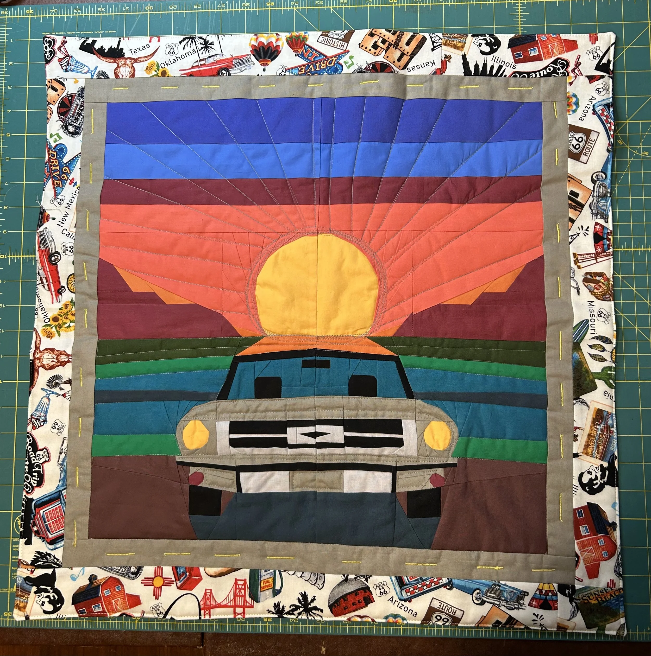 Route 66 Sunset 
by Colleen Almeida Smith
*
This quilt is based on JuliusHandmade's Beach Sunset pattern. I changed it to reflect both the colors of the Oklahoma sunsets I love and the landscape. I added a border and backing in Route 66 fabric.