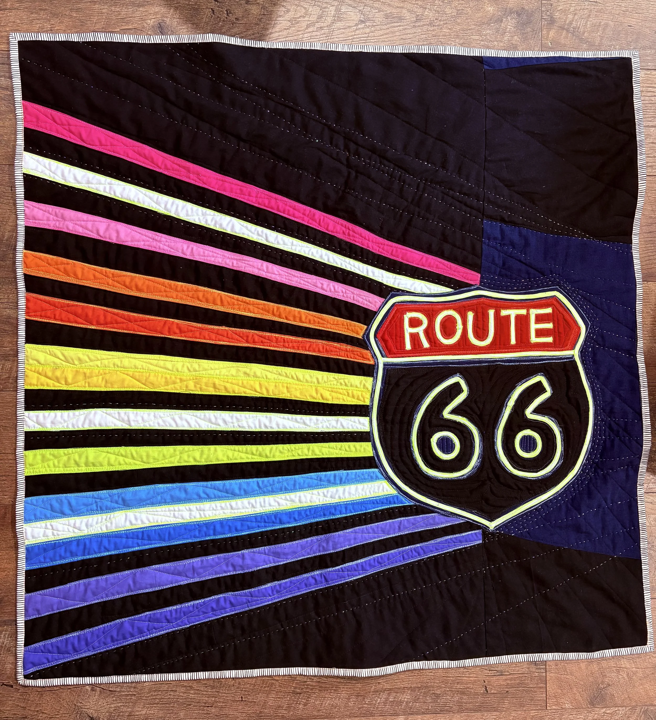 Neon Journey 
by Lisa Swinney
*
Neon Journey pays tribute to traveling Route 66, then and now, and how motion, darkness, and light can become a quilt. The challenge was creating movement while keeping it quilt-like. I used piecing, layered appliqué, 