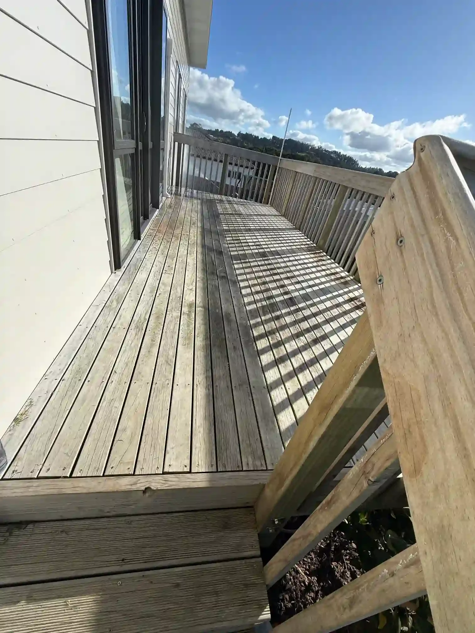 Timber deck cleaning in Point Chevalier Auckland, showing improved deck appearance after professional exterior cleaning by Squeegee Boys..webp