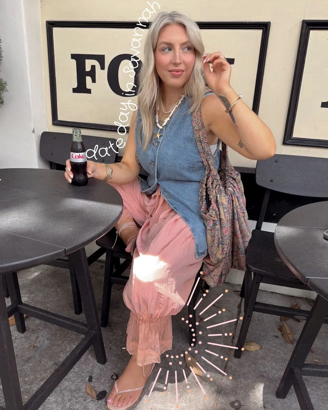 woman sitting at a table holding a diet coke
