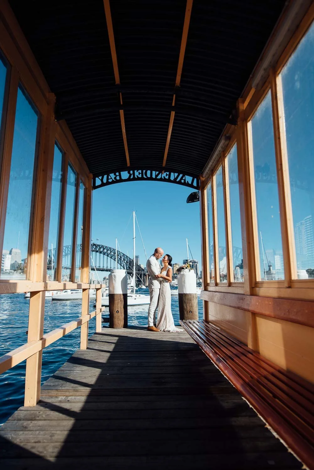 Bride and groom at Lavender Bay wharf with Sydney Harbour bridge in the background