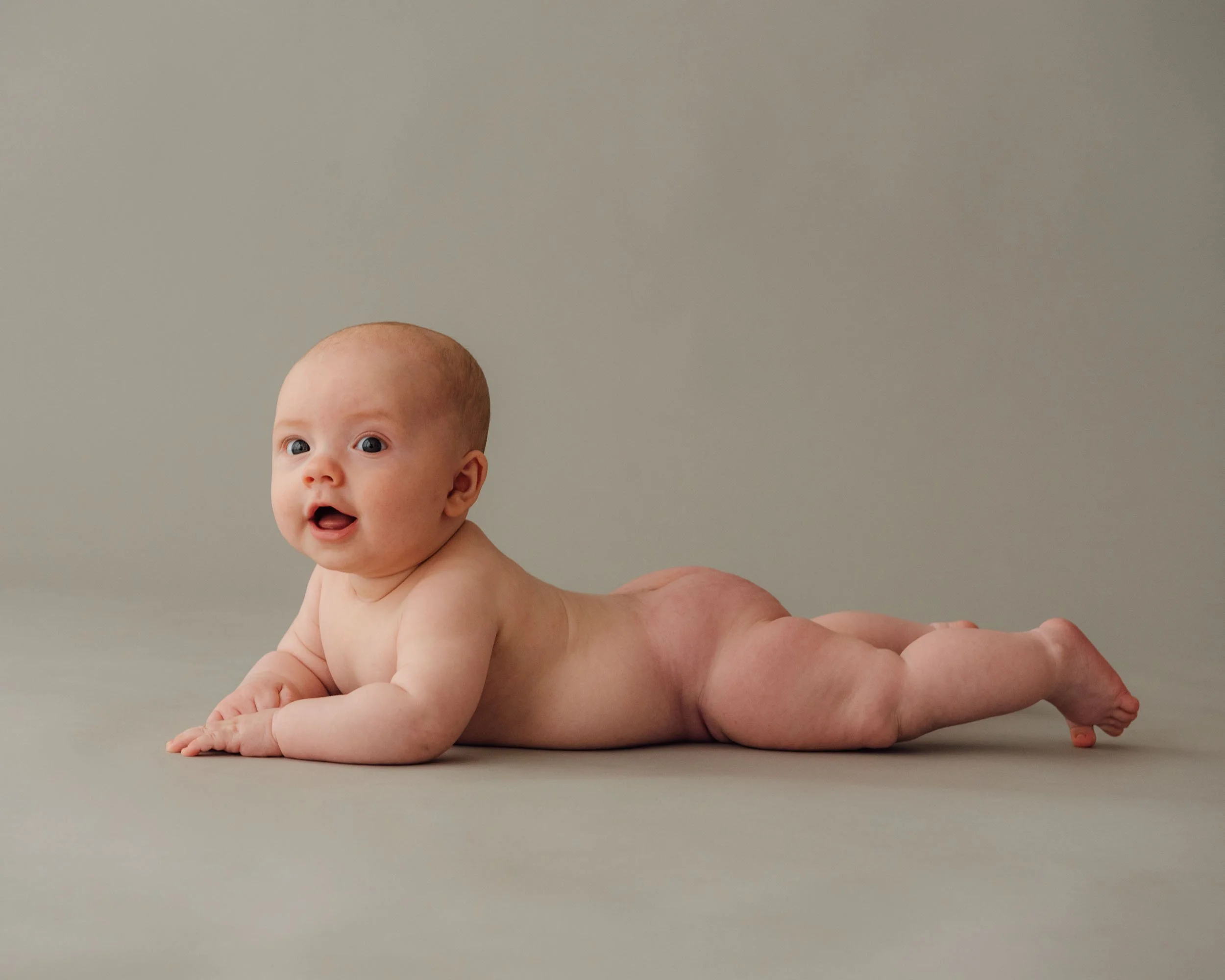 baby photoshoot of 5 month old lying on studio background