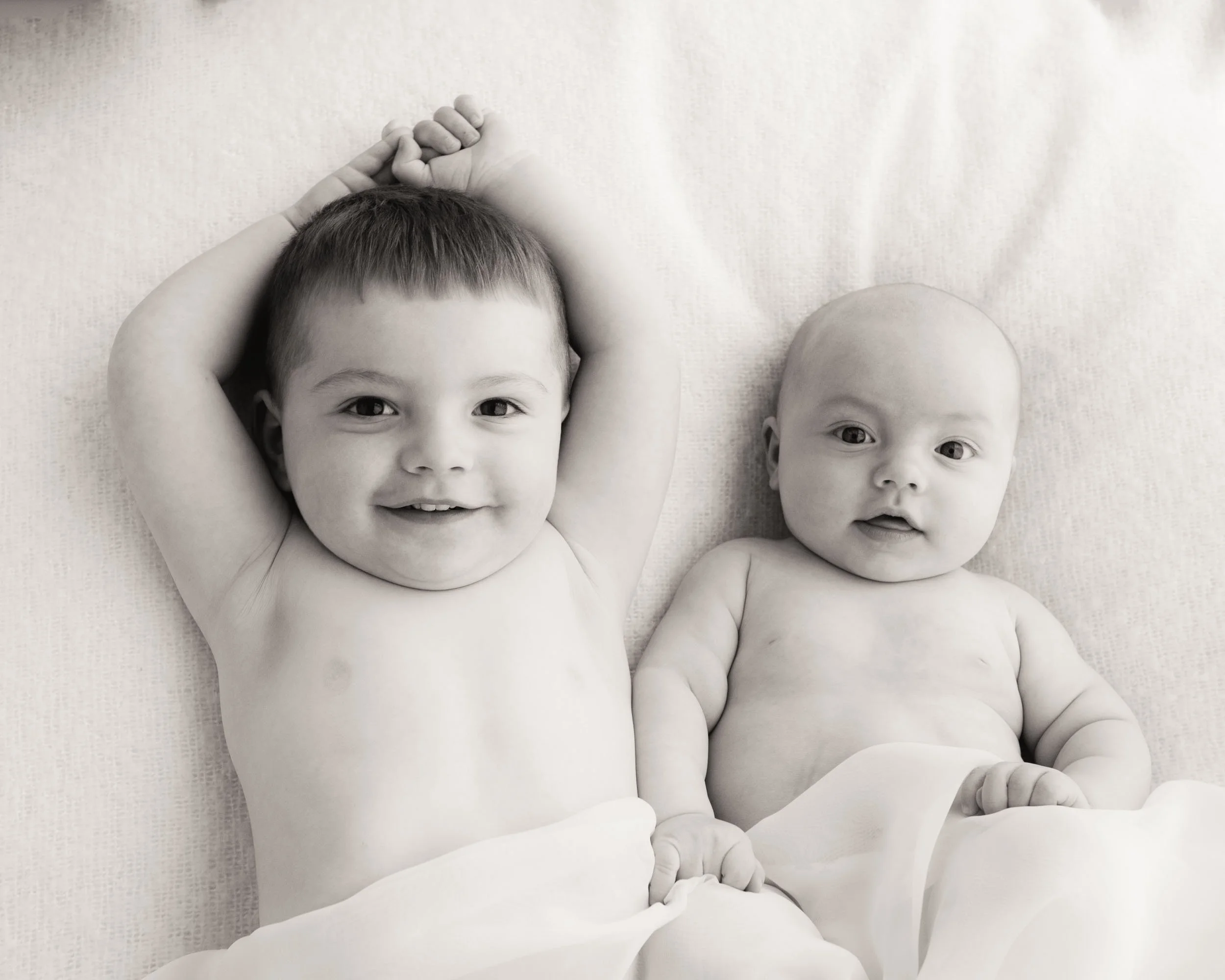 sibling baby photography of toddler smiling next to his 4 month old brother