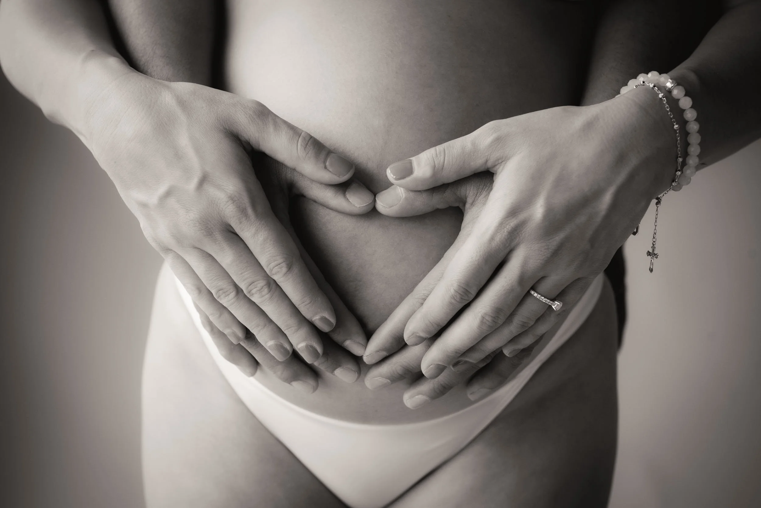 love heart shaped hands on pregnant belly portrait