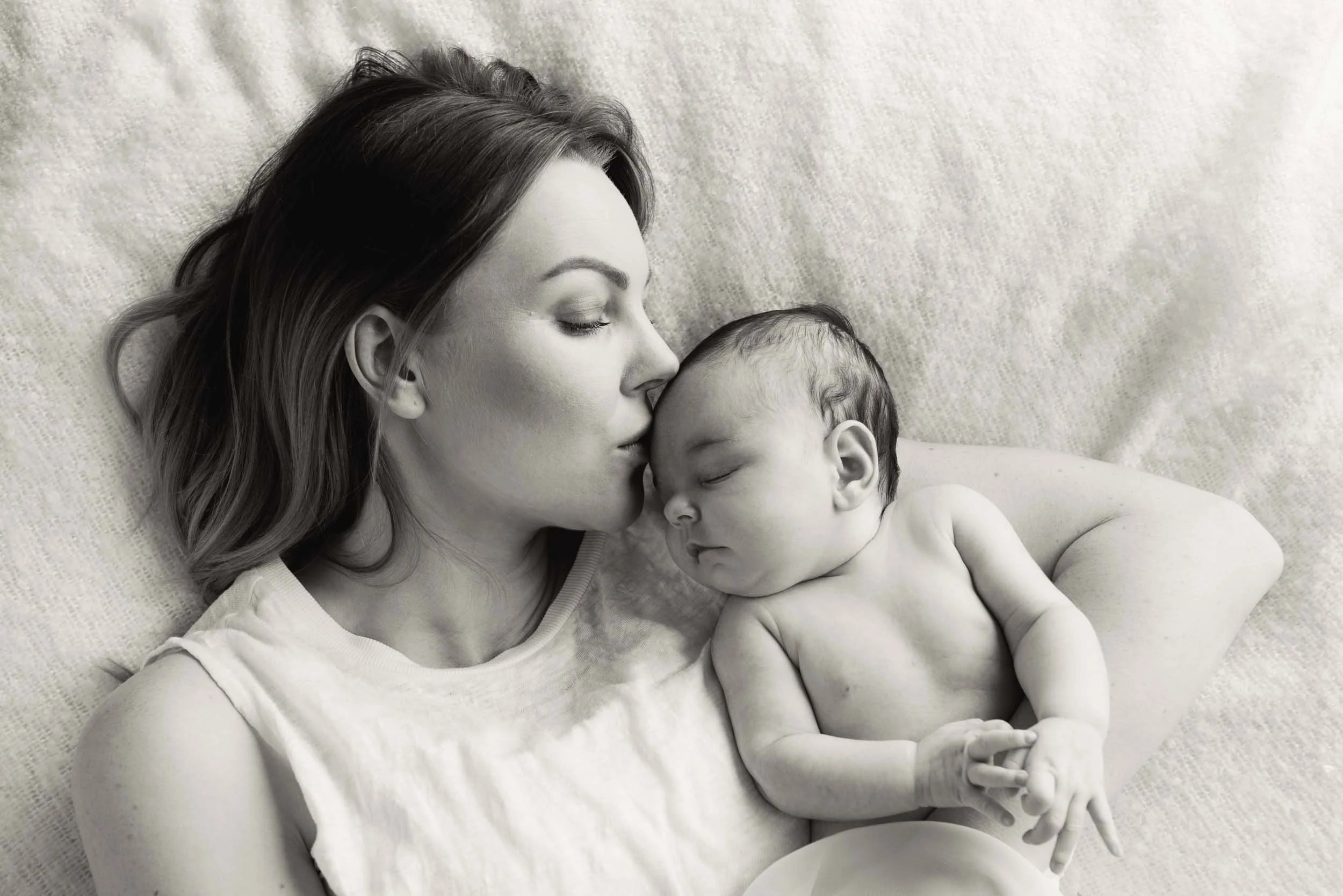 mother kissing her baby daughter