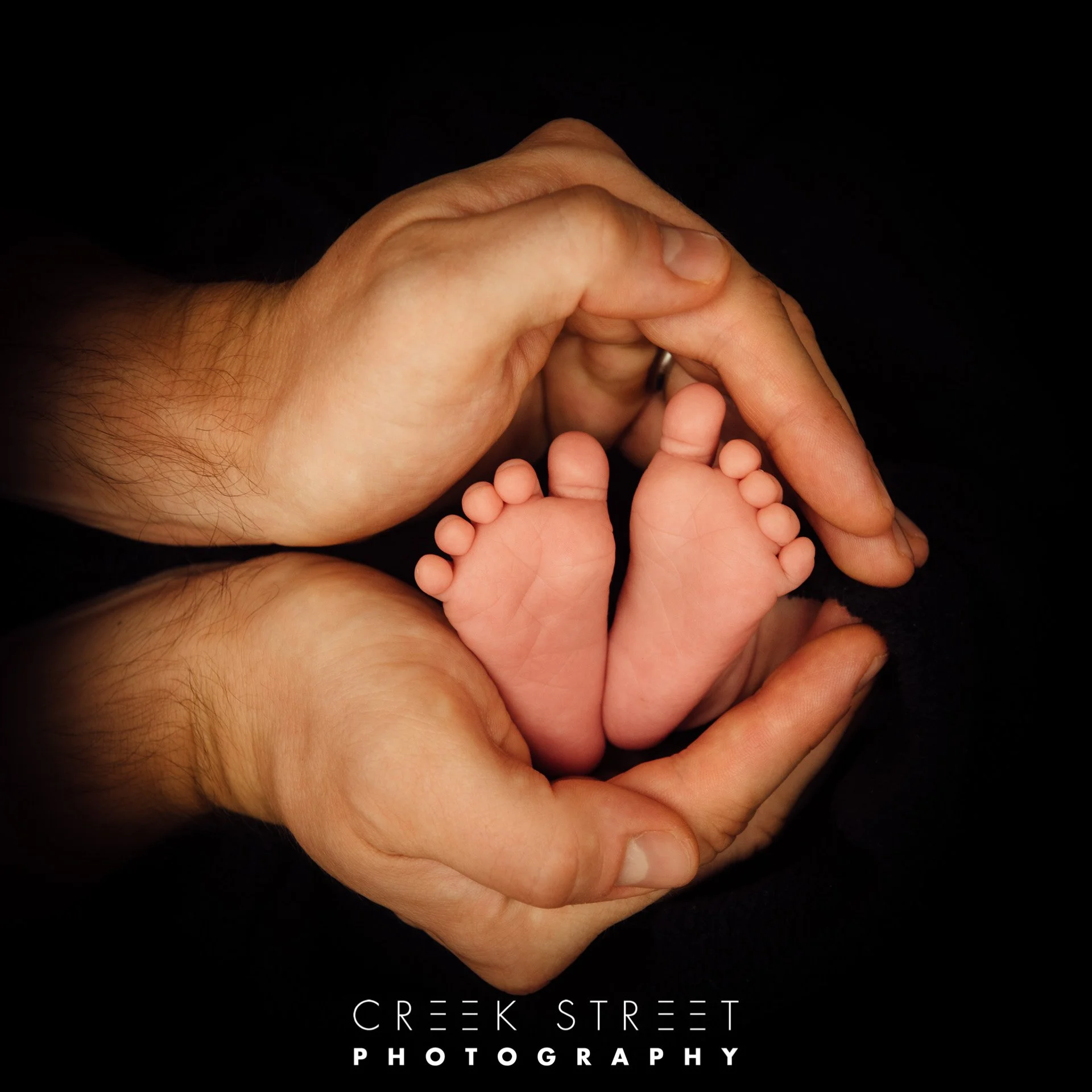 newborn photography of feet in dads hands.jpg