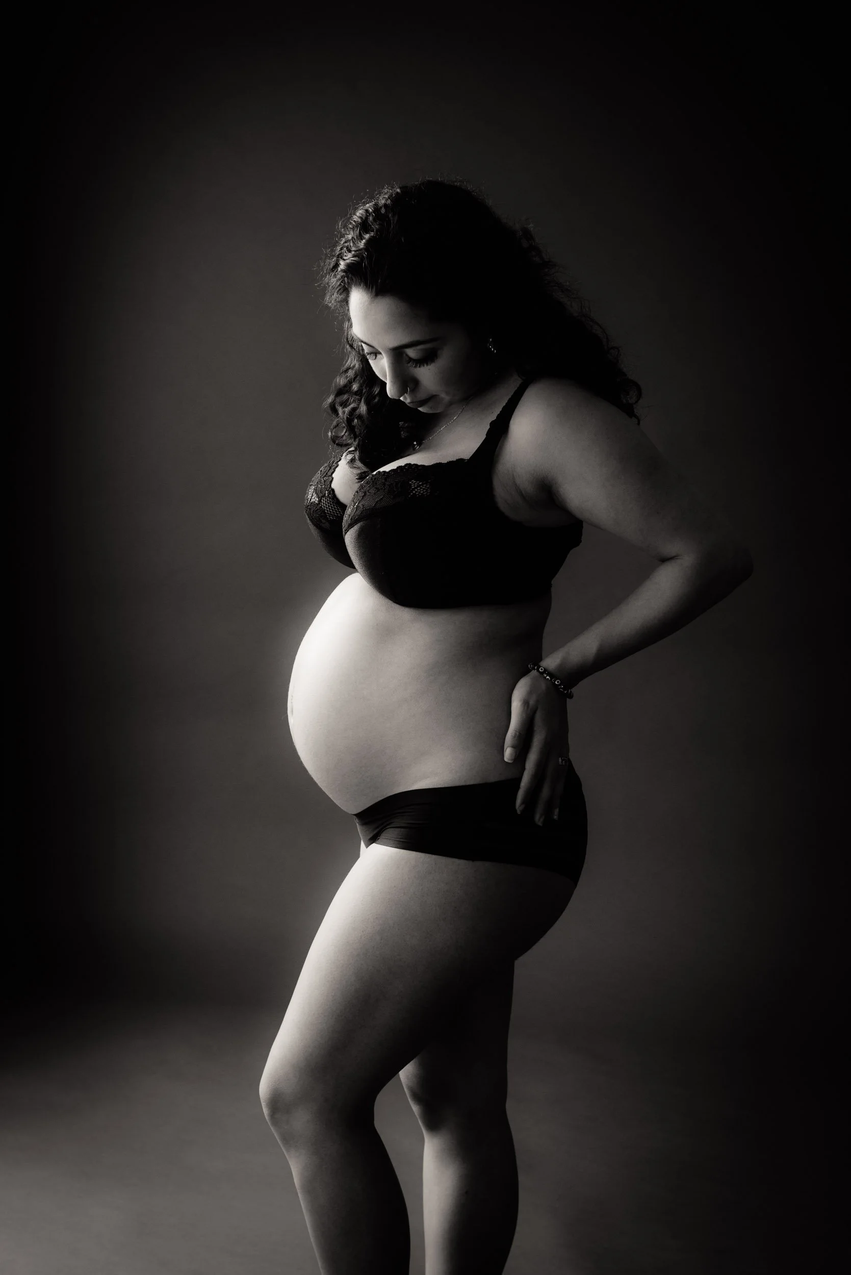 Maternity photoshoot of a woman in black lace lingerie 