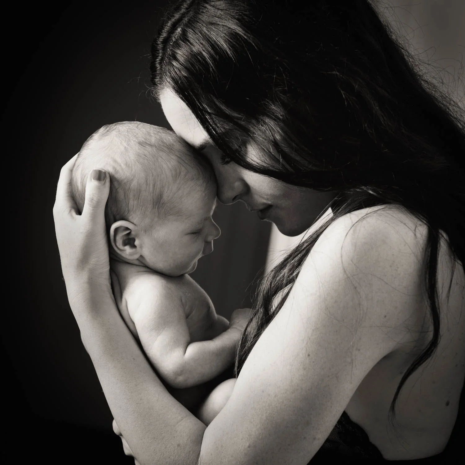 newborn photoshoot of mother and child cuddling