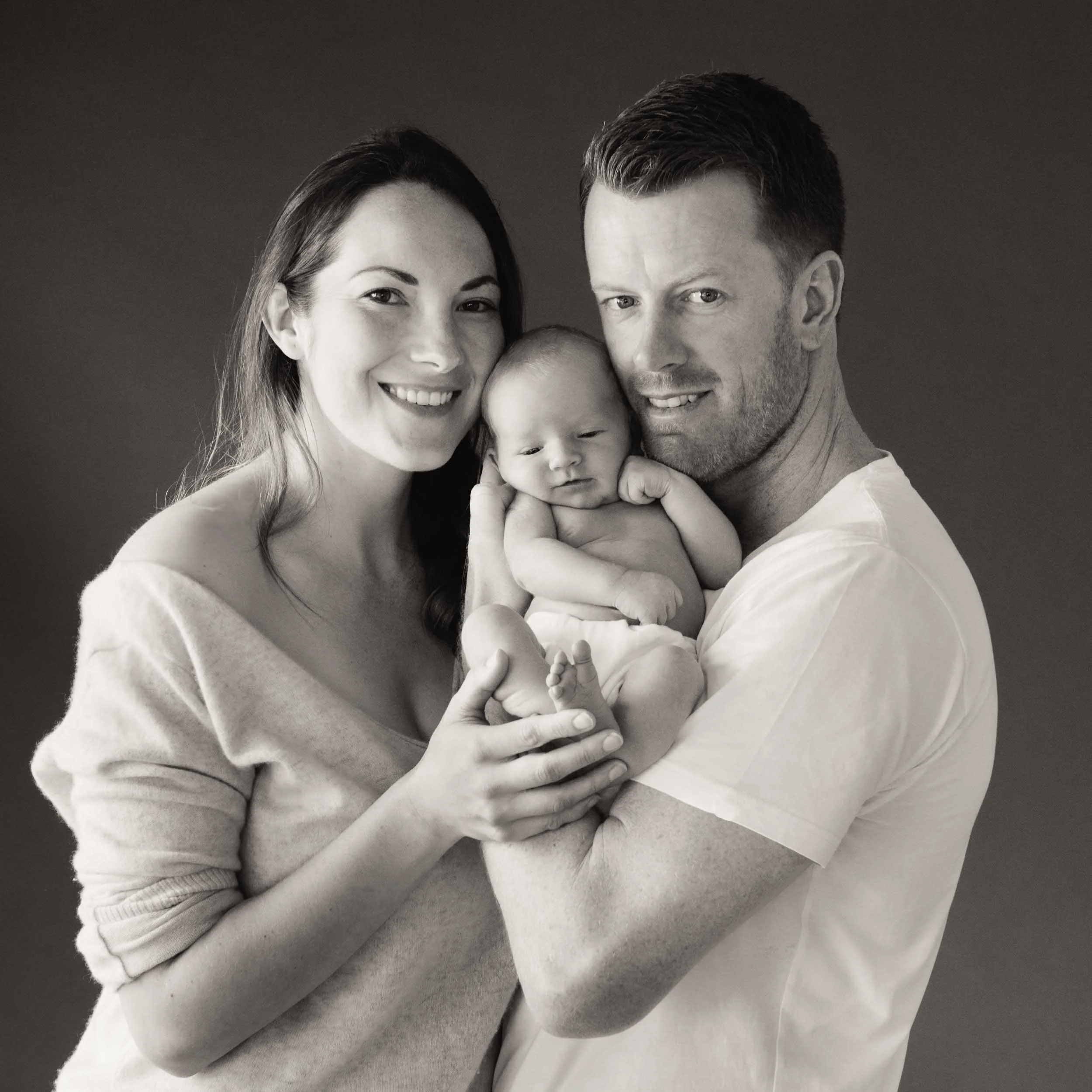 family newborn photography portrait of parents holding baby in black and white