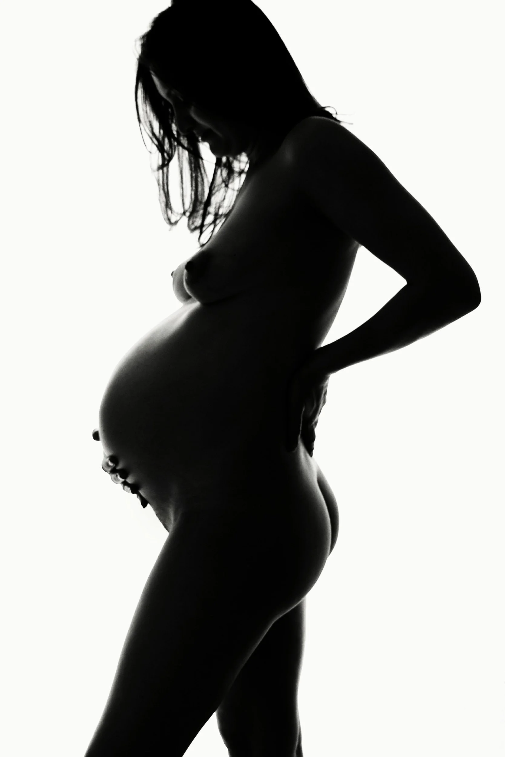 Maternity silhouette photography of woman with long hair holding belly