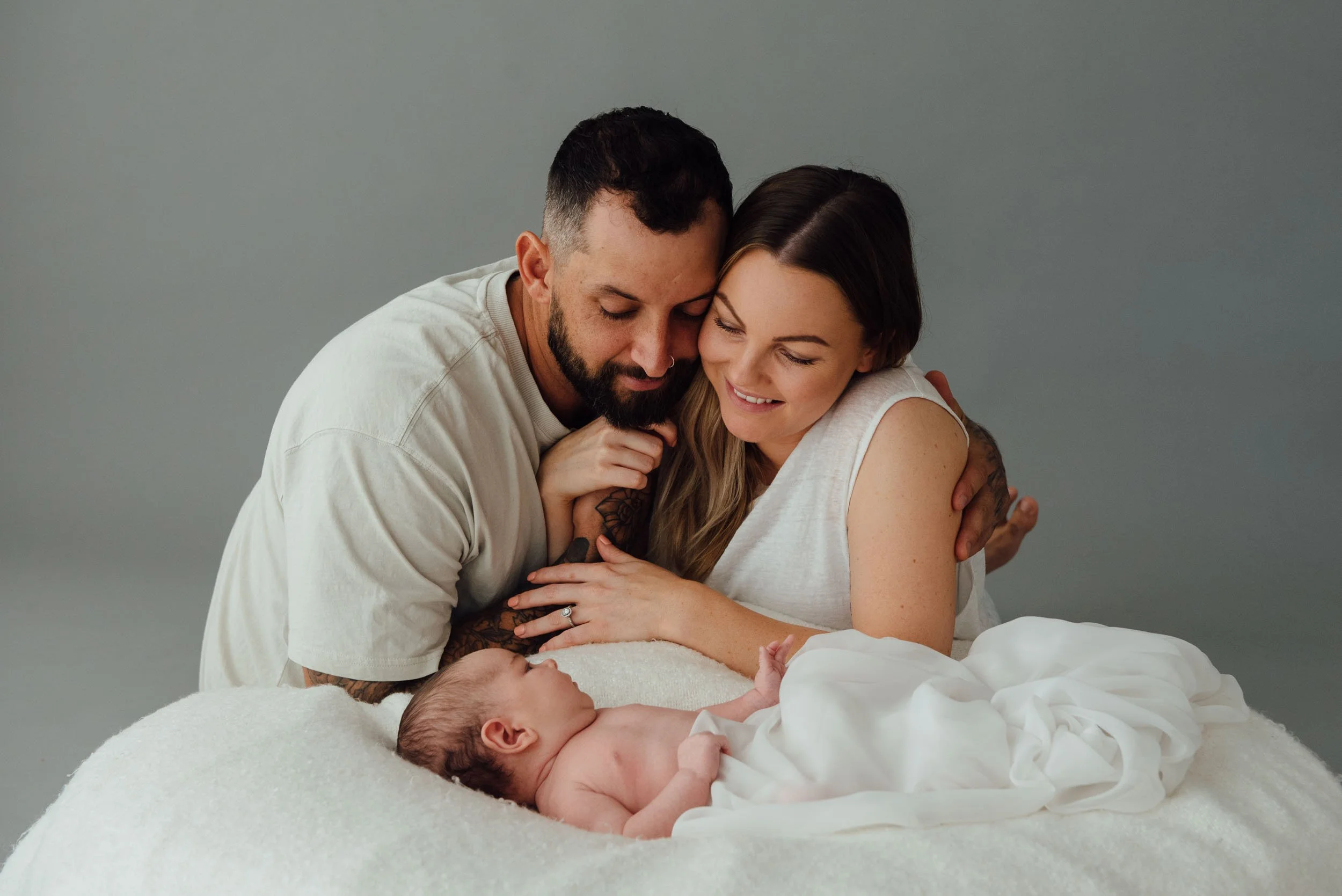 baby photography of 4 month old lying on pillow looking at his parents