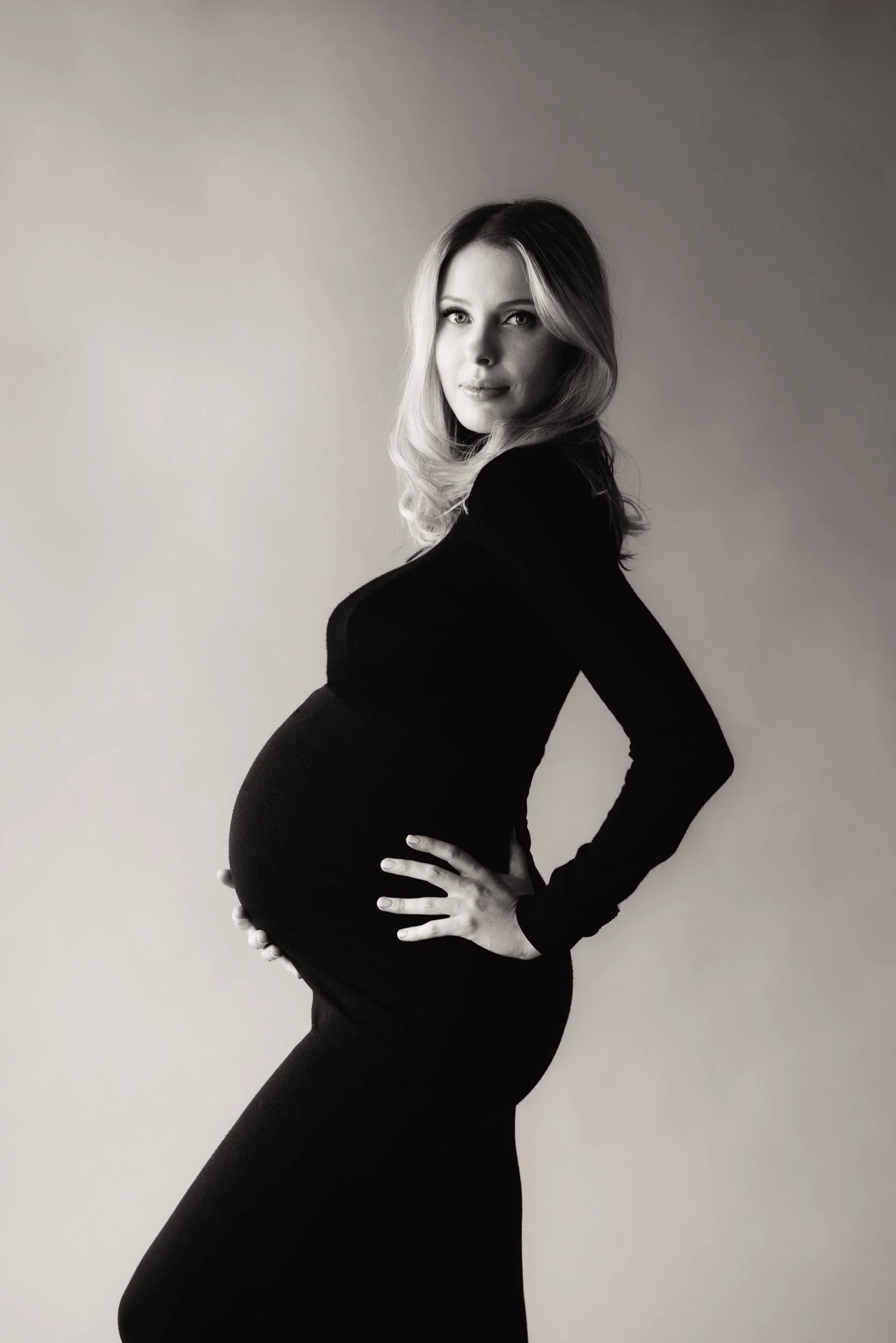 Classic maternity photography of woman in tight black dress