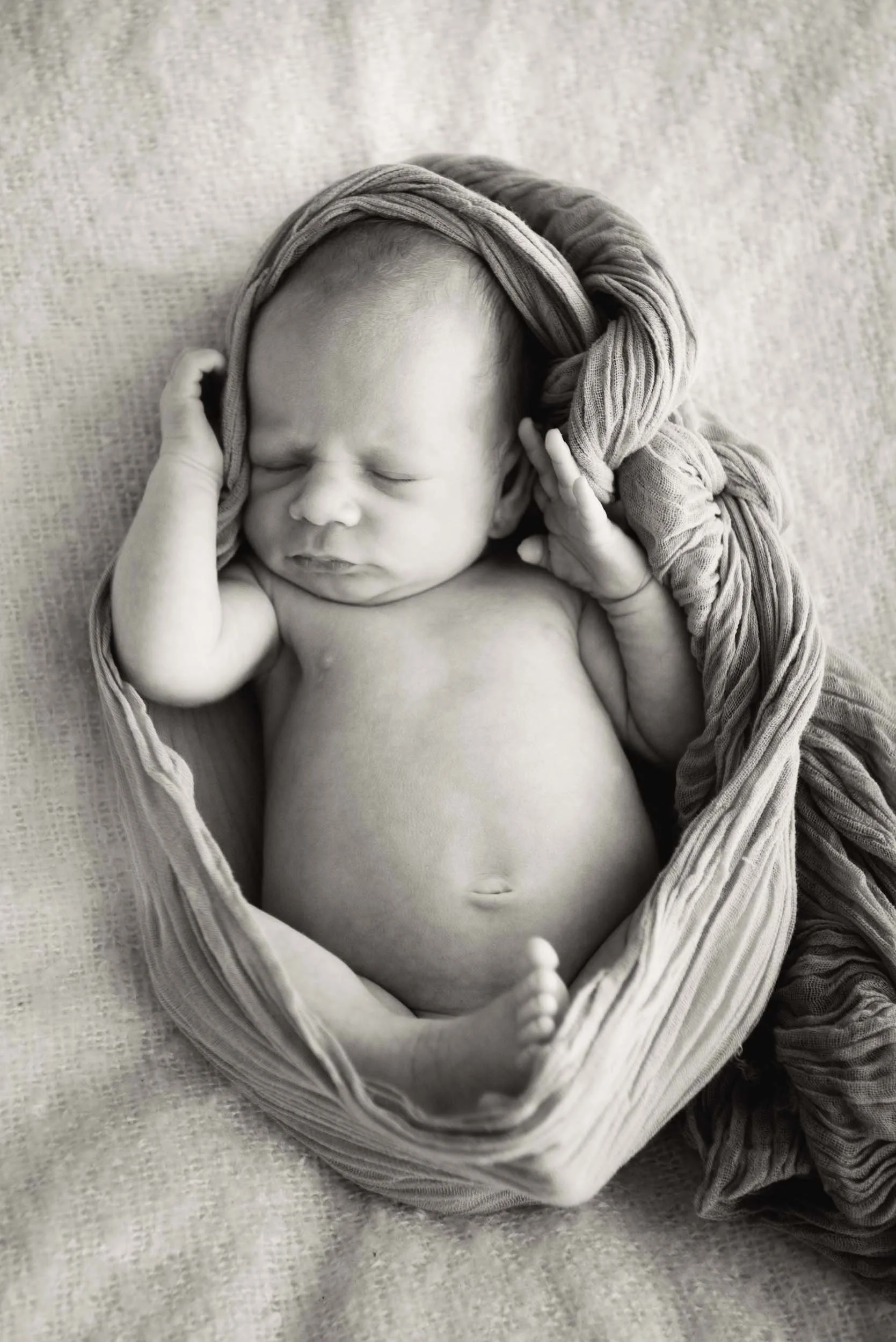 newborn photography of sleeping baby wrapped in swaddle