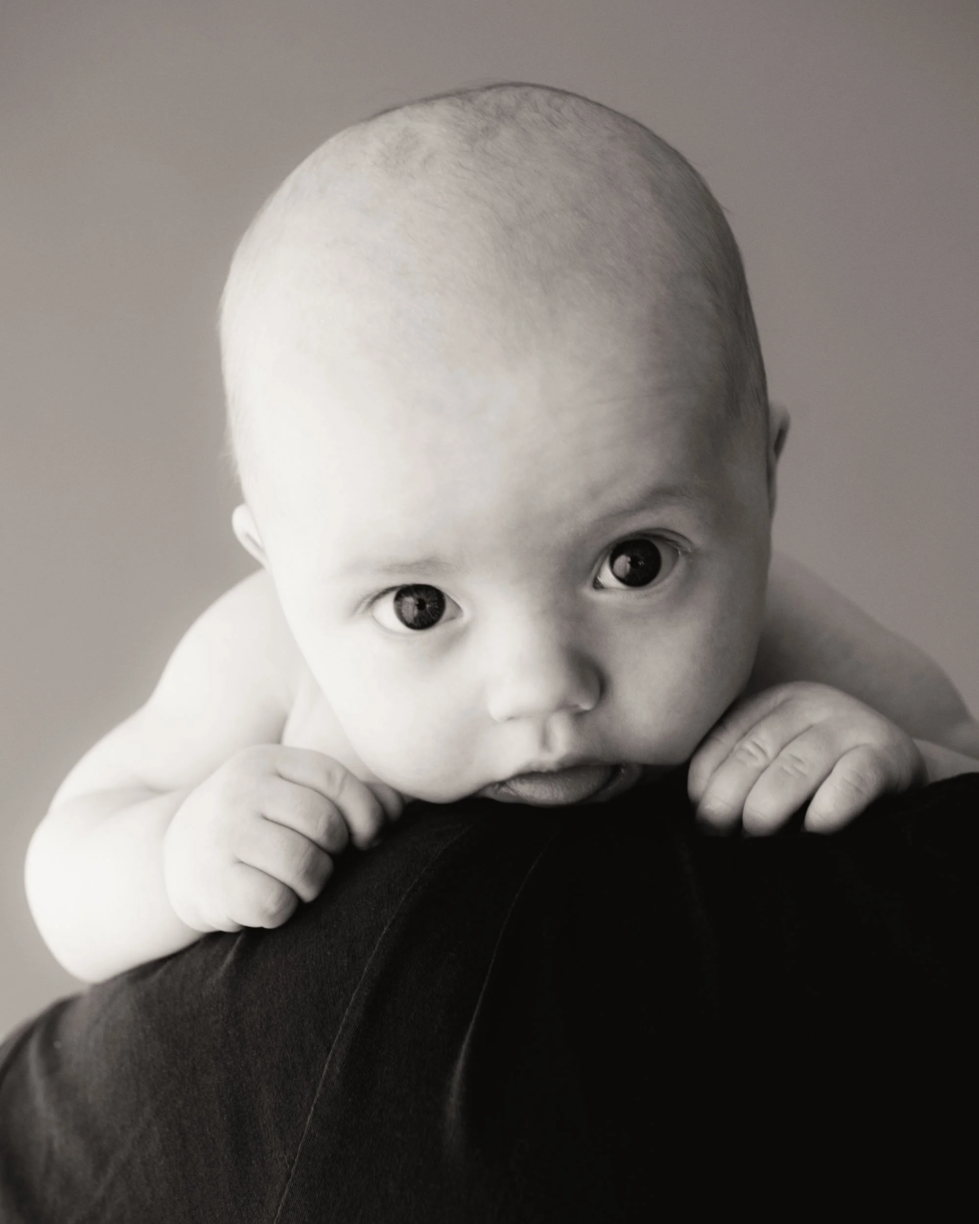 4 month old baby looking over fathers shoulder