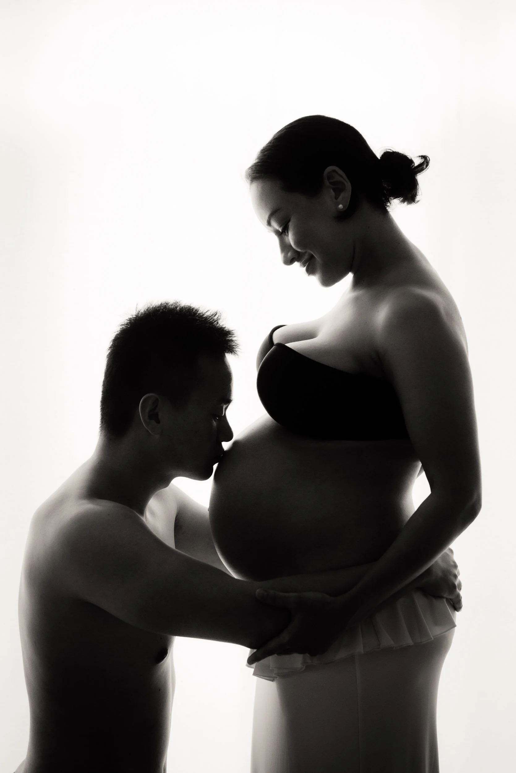 husband kissing wife's belly during a maternity photoshoot in Sydney