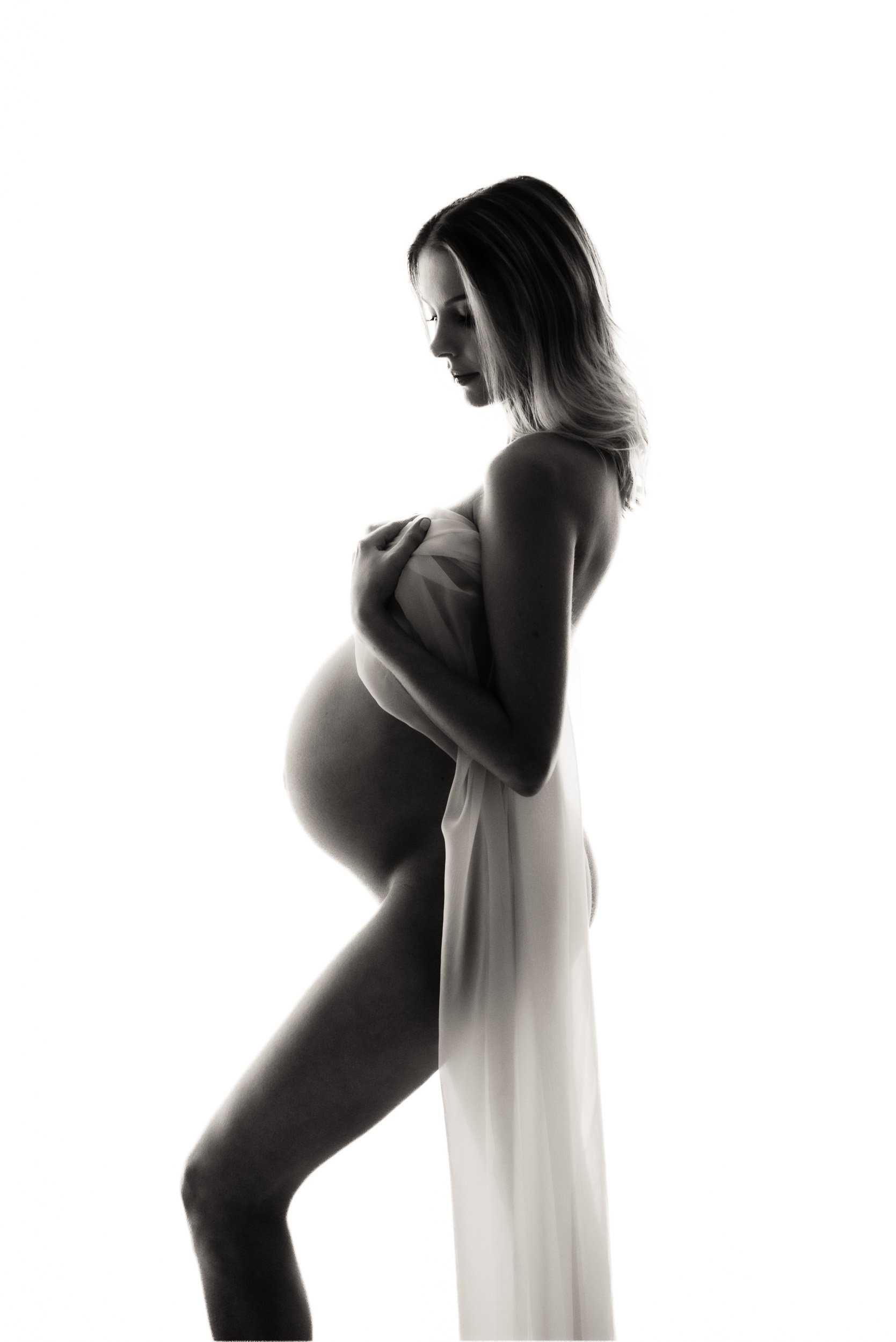 elegant maternity photography shoot of a woman draped in chiffon material