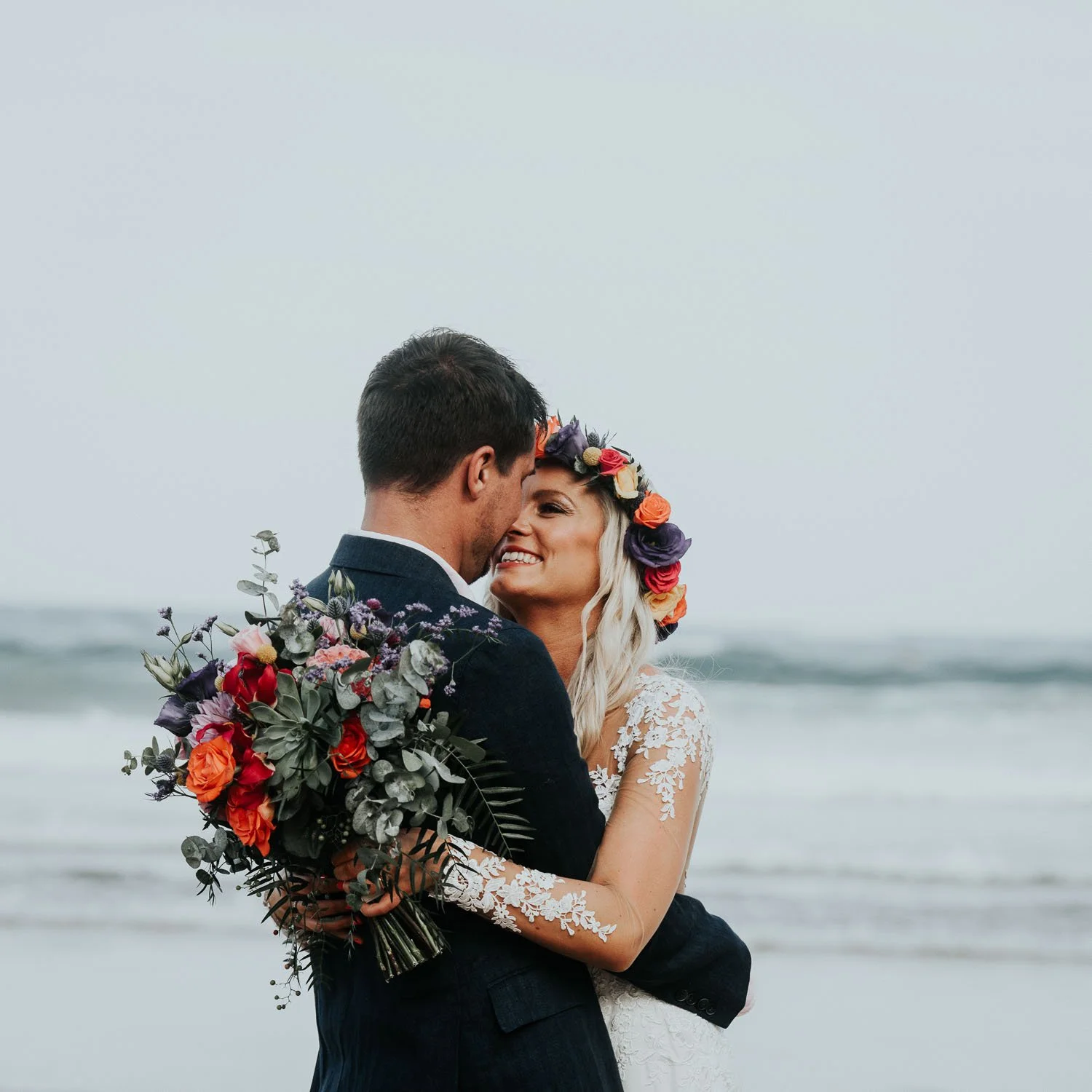 Newlyweds romantic beach photo of bride and groom. Bride with flower crown and wedding flowers, freshwater Beach Manly Sydney