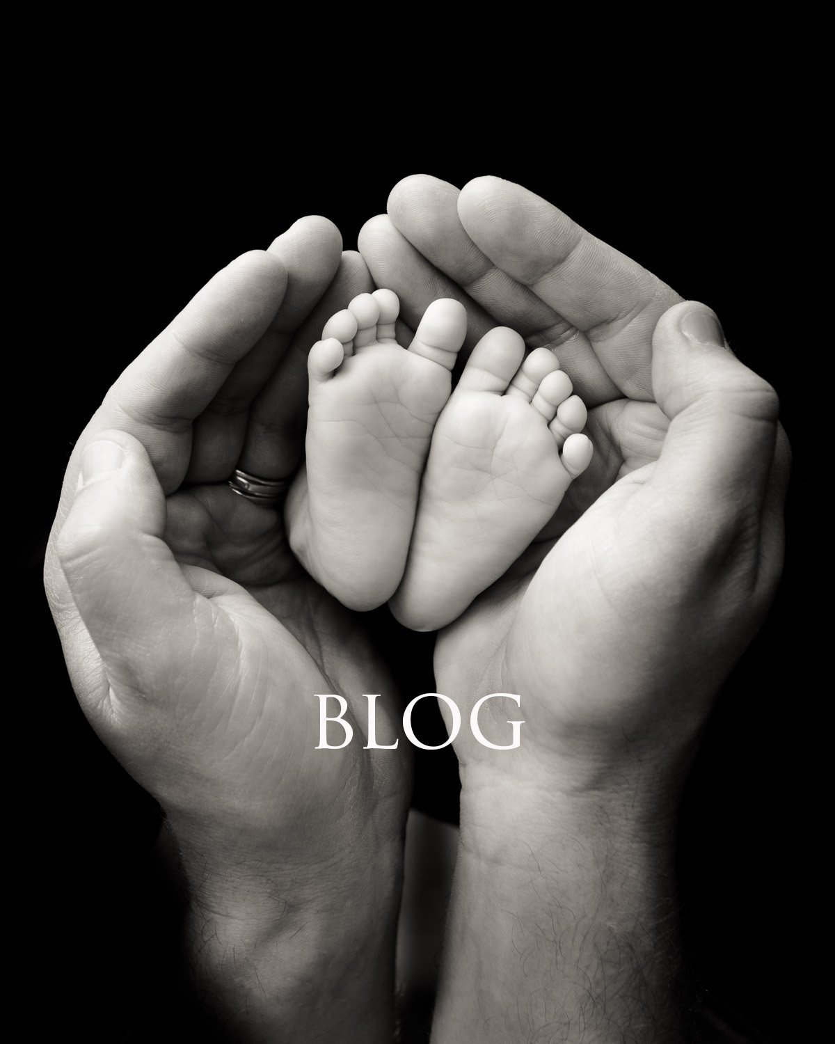 Black and white photo of adult hands gently cradling tiny baby feet, with the word "BLOG" written beneath.
