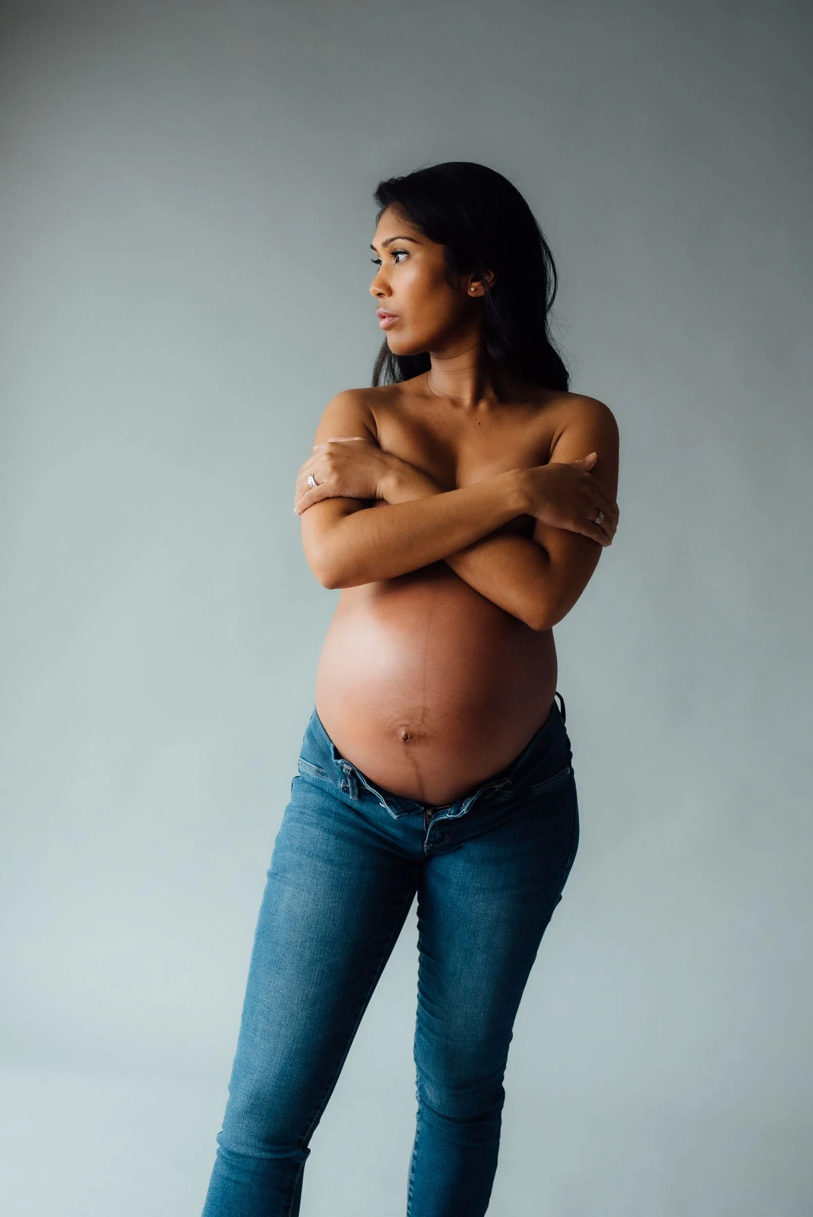 Woman wearing blue jeans in a maternity photography session