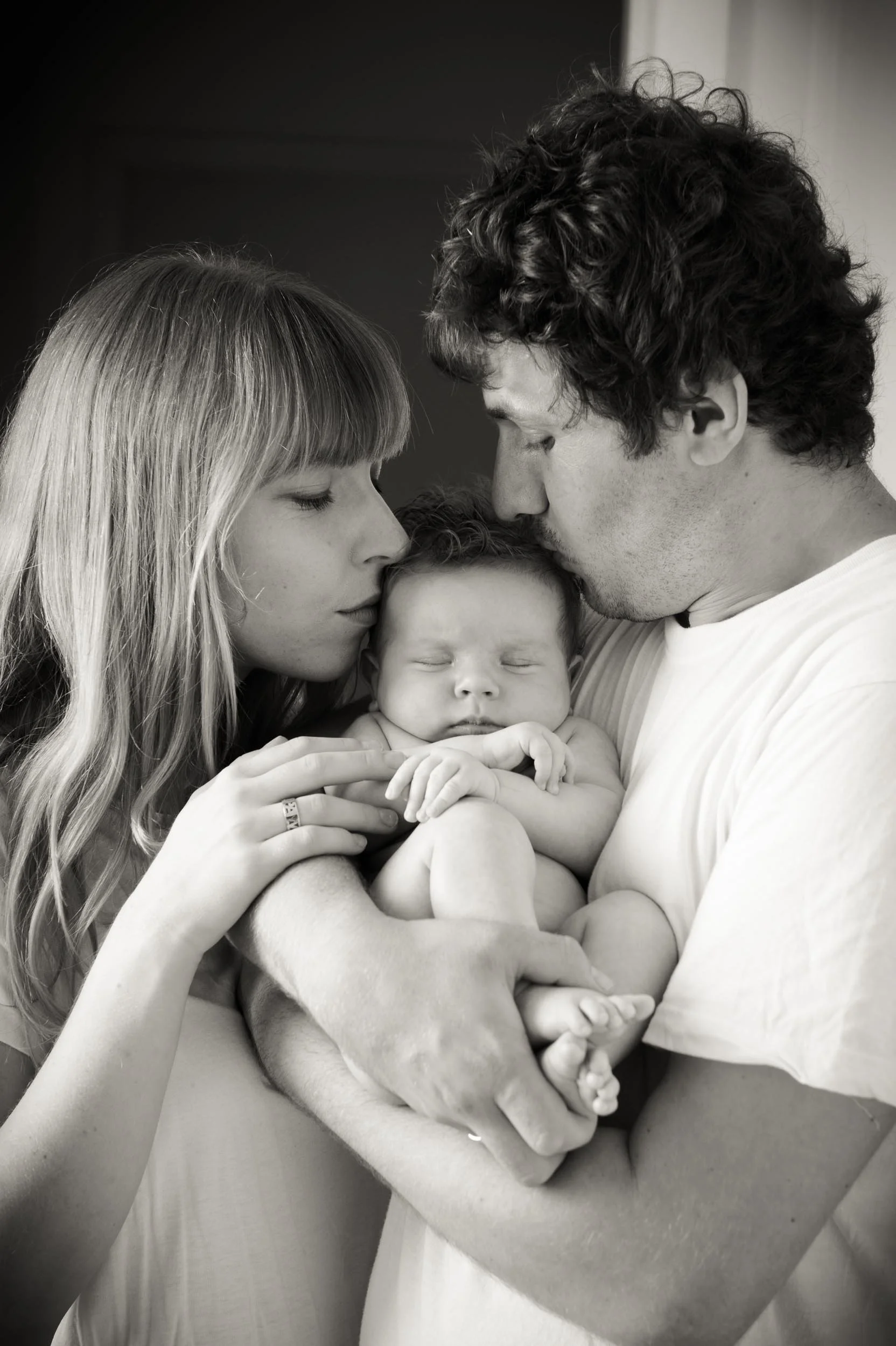 baby photoshoot of parents kissing their 5 month old son