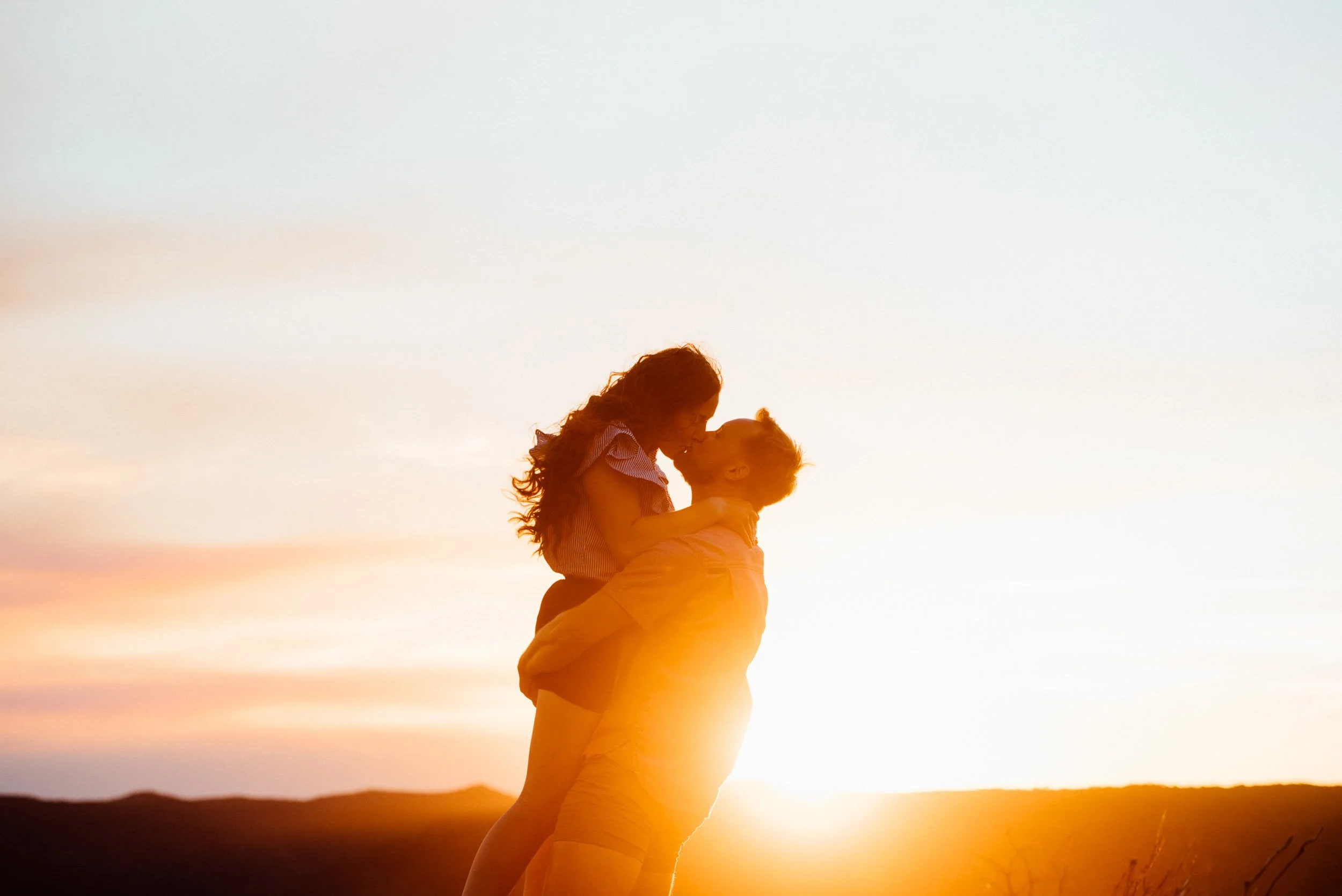 romantic sunset photoshoot of couple kissing on the northern beaches