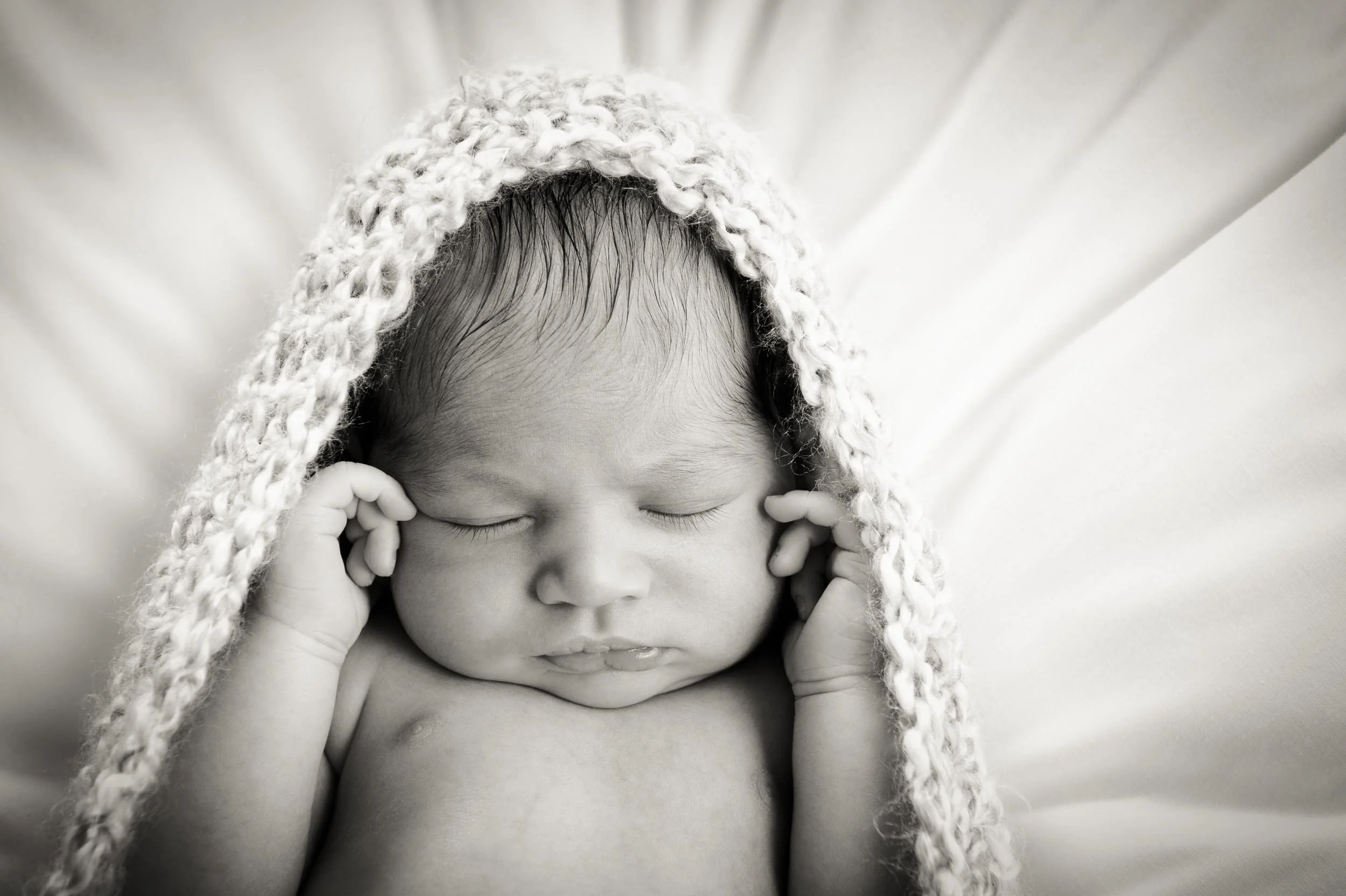 newborn photography of sleeping baby in a crocheted cocoon