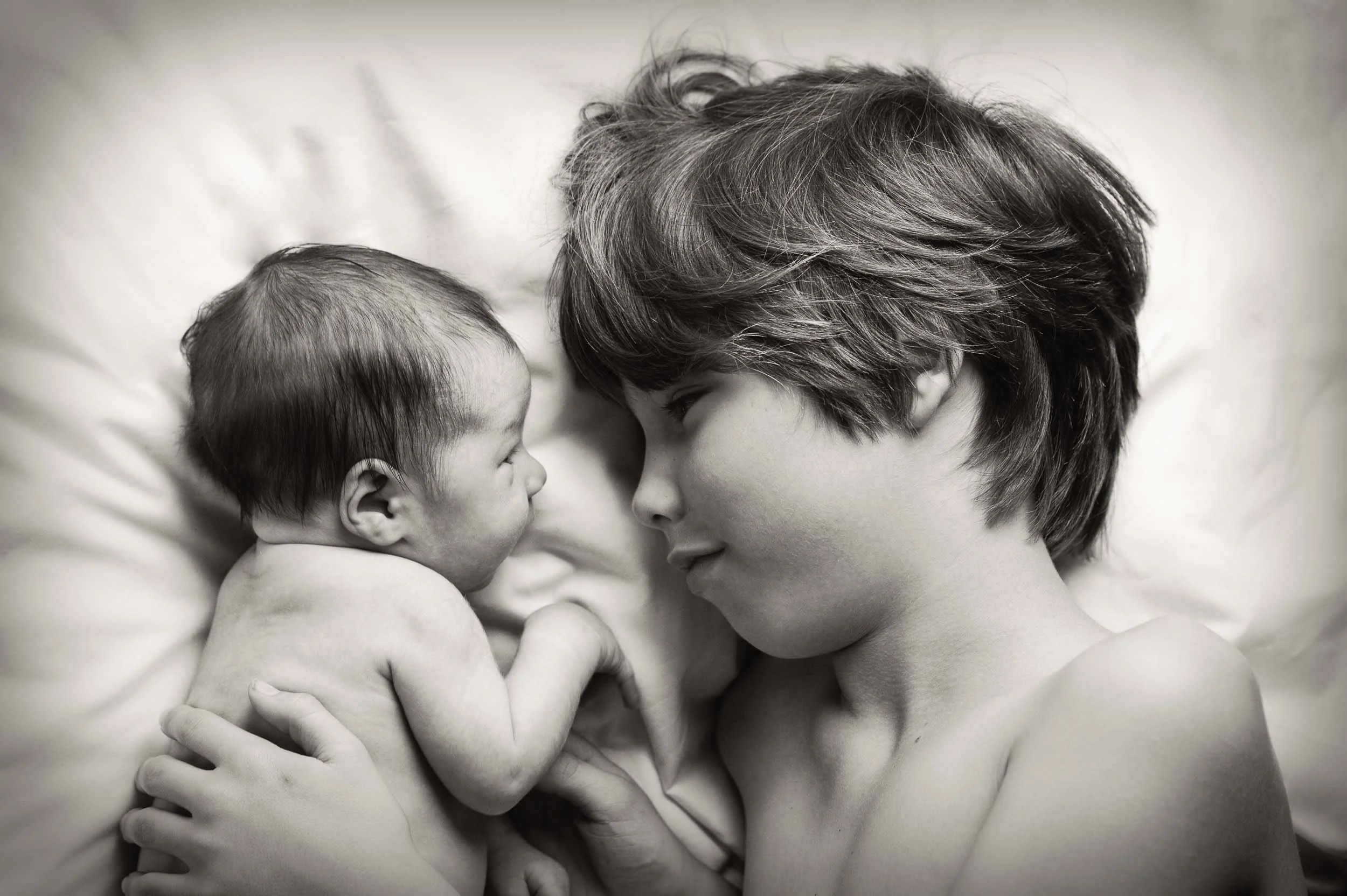 sibling newborn photography of boy cuddling his 2 day old brother