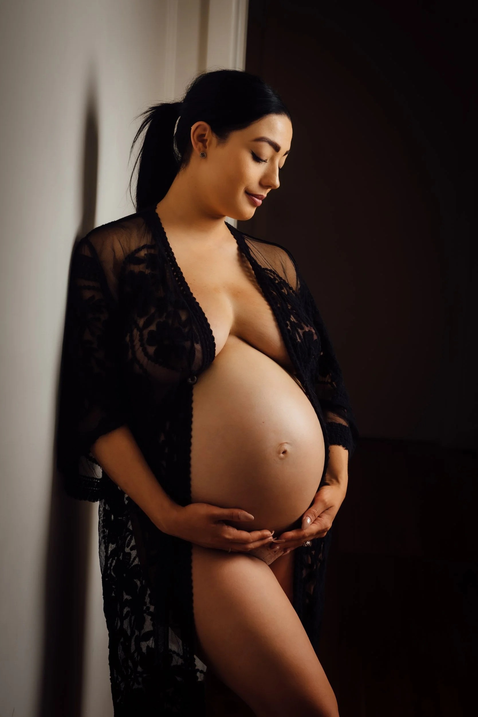 Maternity Photography portrait of woman  holding her huge belly