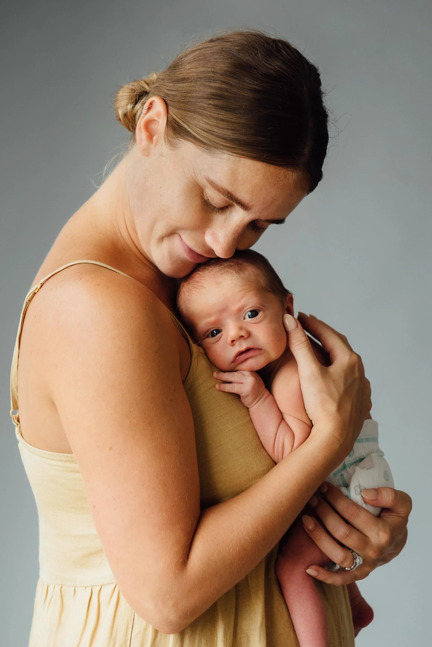 newborn photoshoot of mother cuddling her 6 day old baby