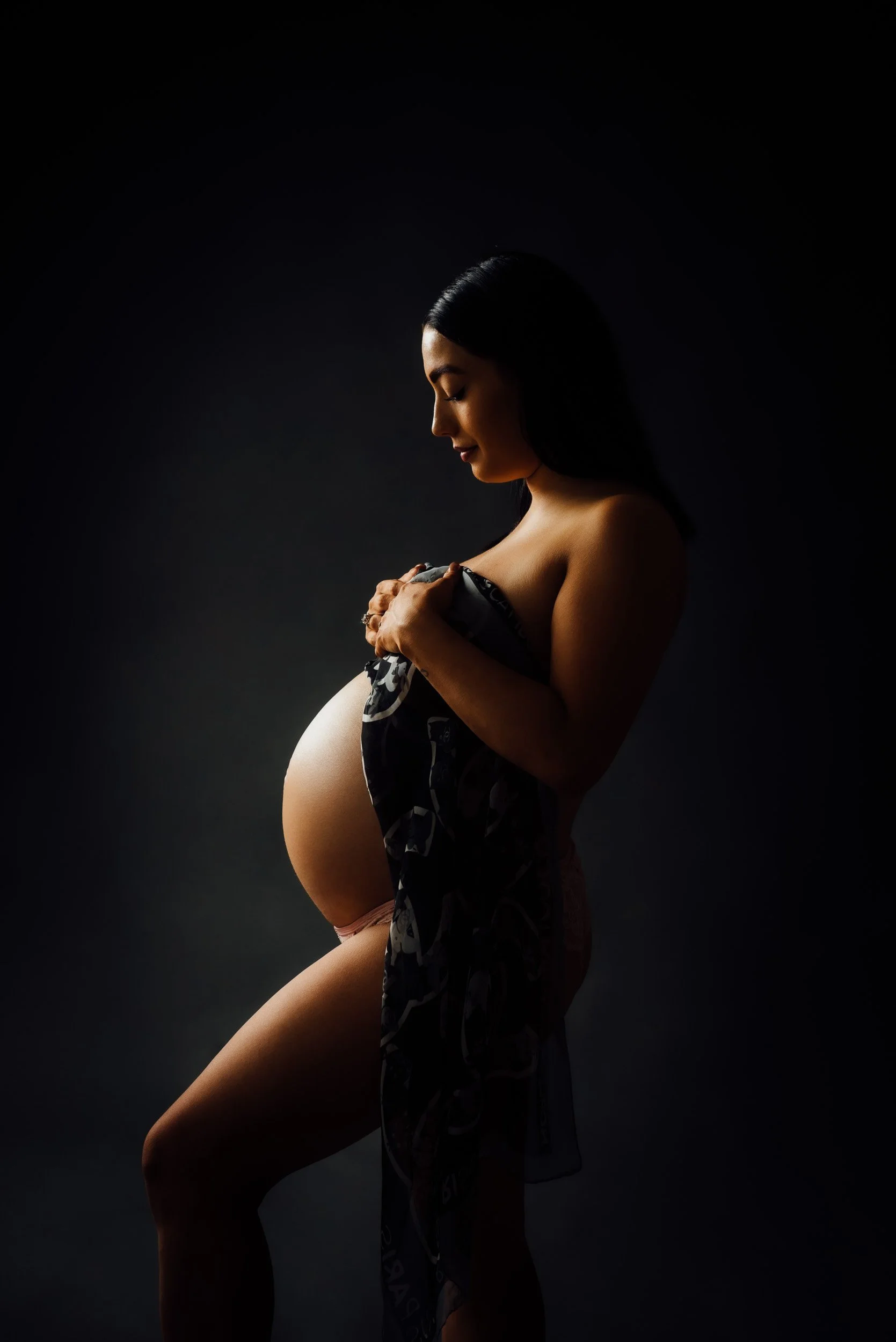 Woman draped in fabric for a maternity photoshoot 