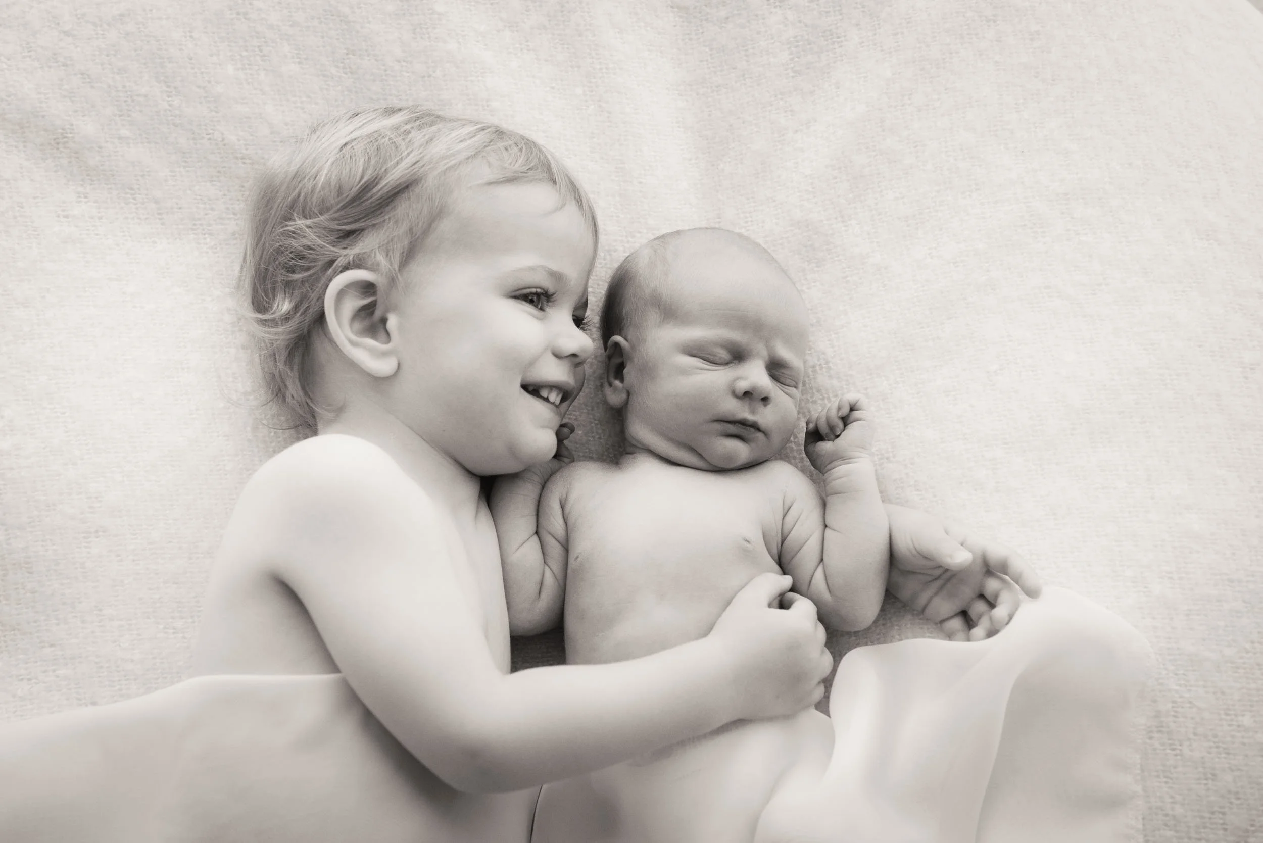 sibling newborn photography of boy cuddling his baby brother